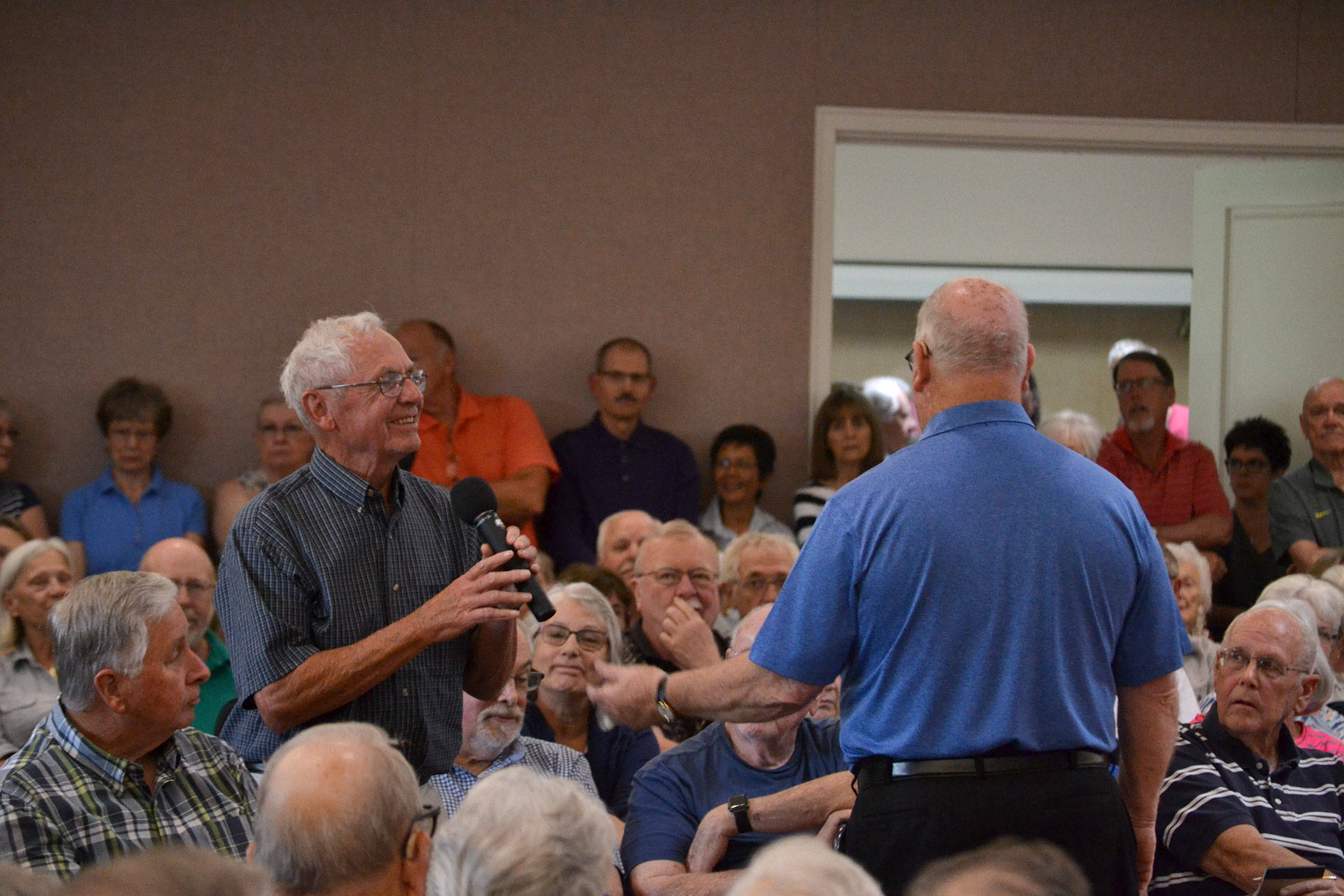 Bruce Mullikin, Sunland Golf & Country Club board president, takes the microphone from Fred Smith, SunLand Owners Association president, to share updates about the financial status of the club. “I’m an optimistic believer we can do this,” Mullikin said. Sequim Gazette photo by Matthew Nash