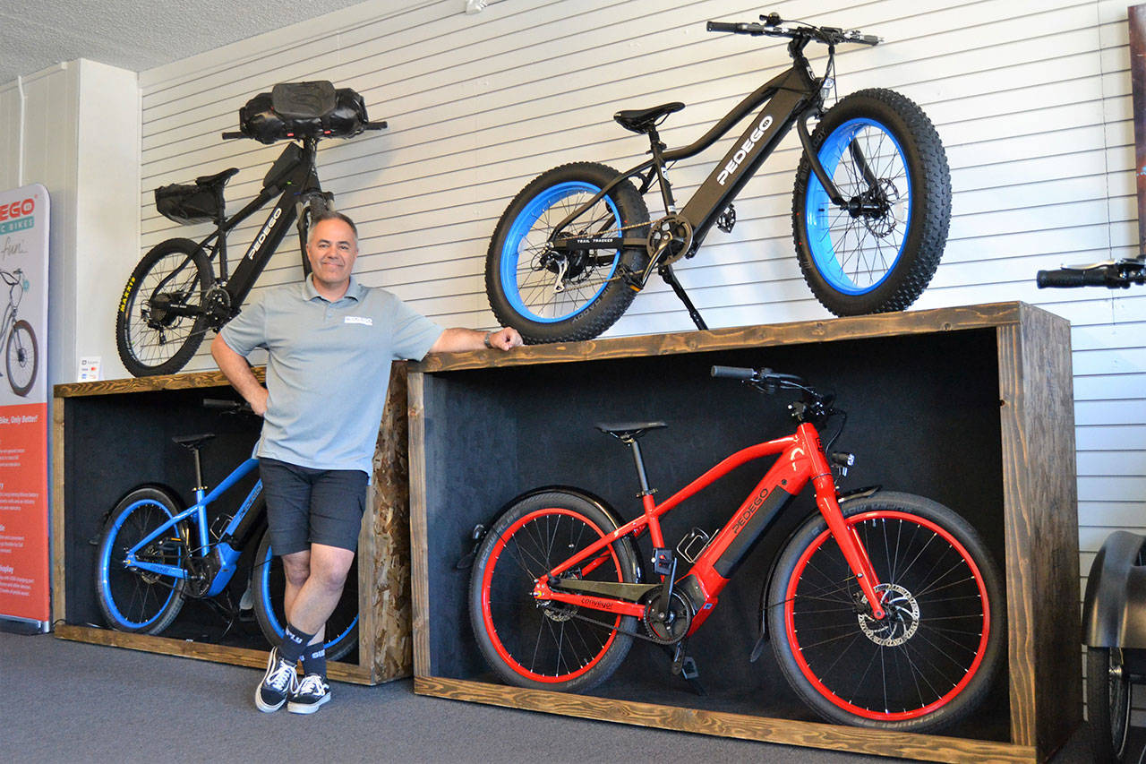 Garth Schmeck offers free rides, rentals, and sales of Pedego electric bikes in his new downtown shop Pedego Sequim. He said e-bikes help alleviate people’s fears of hills and distances. Sequim Gazette photo by Matthew Nash
