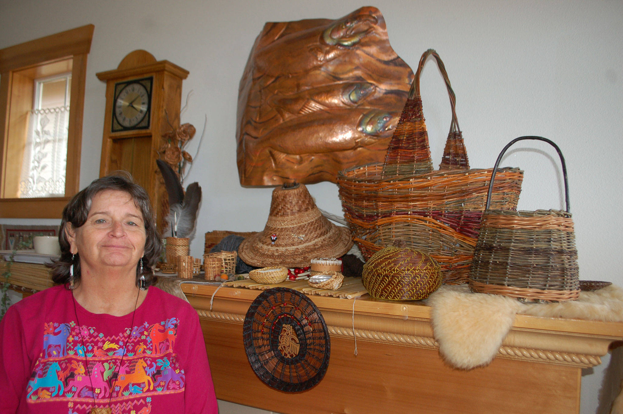 Cathy MacGregor stands in her Sequim home that is decorated with a variety of her weavings, from baskets to hats to jewelry. Sequim Gazette photo by Erin Hawkins