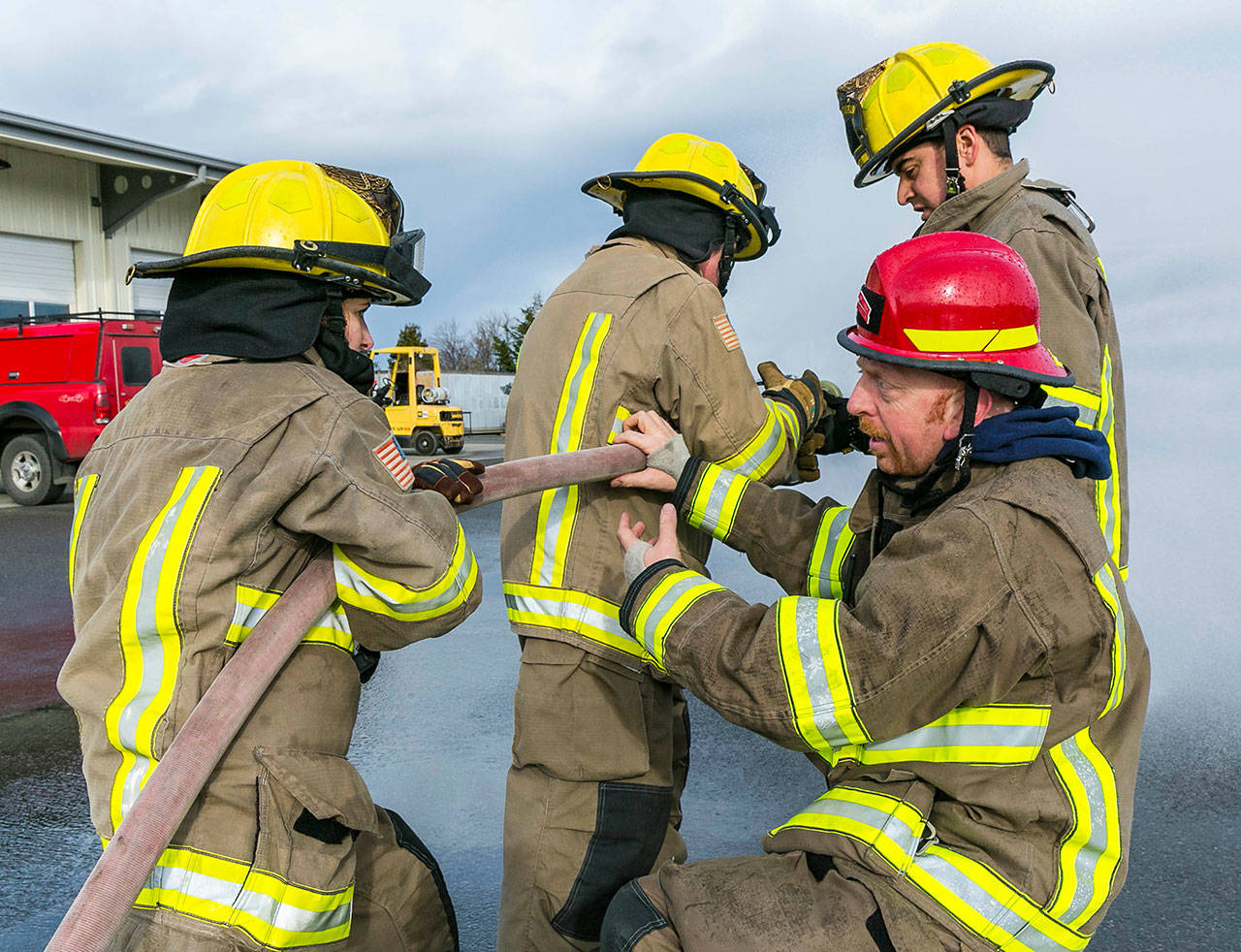 Marc Lawson, shift captain with Clallam County Fire District 3 (bottom right), helps fellow firefighters in a training exercise at the district’s training center in Carlsborg. The fire district is asking voters to approve a “levy lid lift” in the Nov. 6 general election. Photo by Linda Barnfather