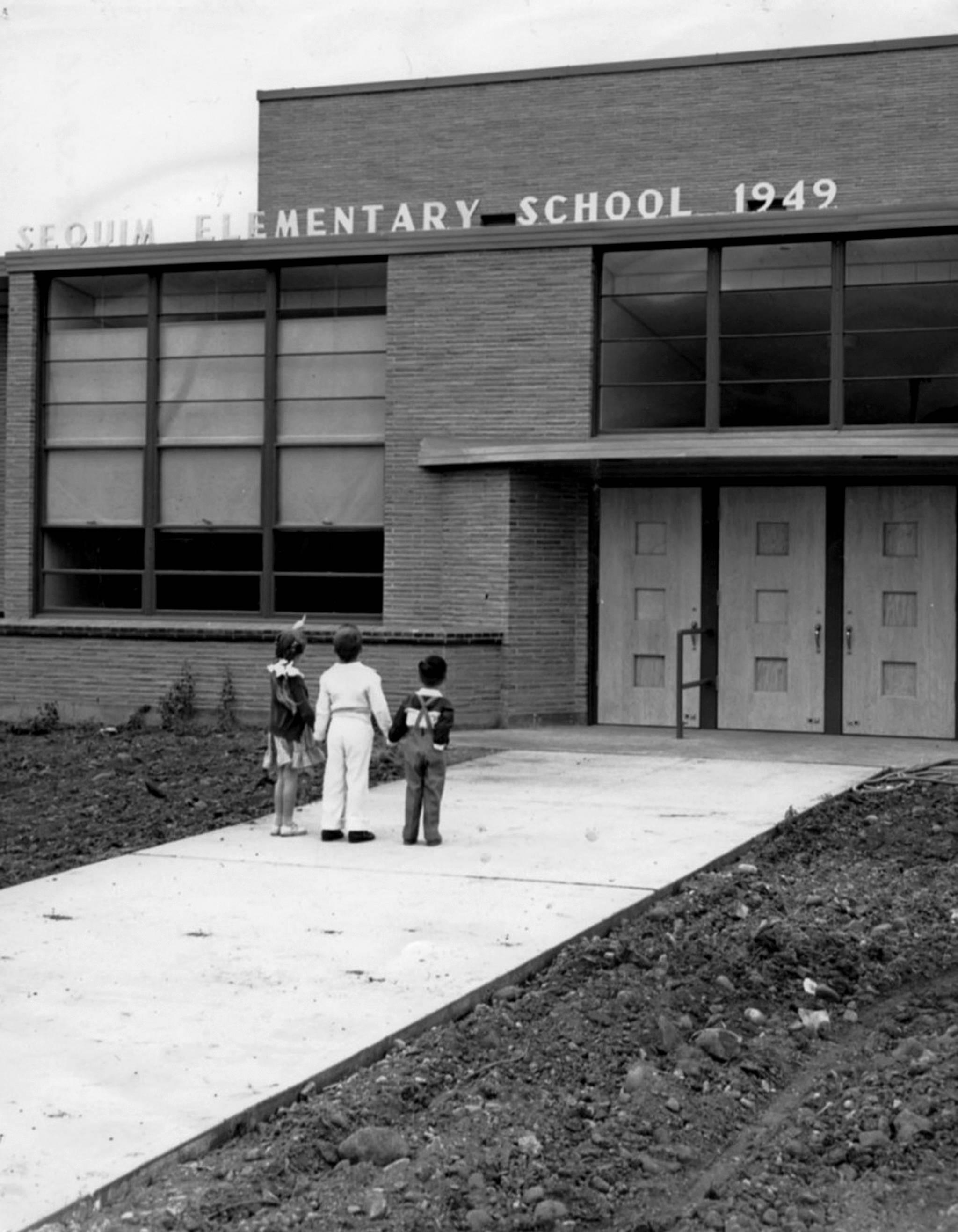 Students look at the new Sequim Elementary School that opened in September of 1949. The school most recently was known as the Sequim Community School that was closed in 2012 and is set to be demolished by the end of the year. Submitted photo