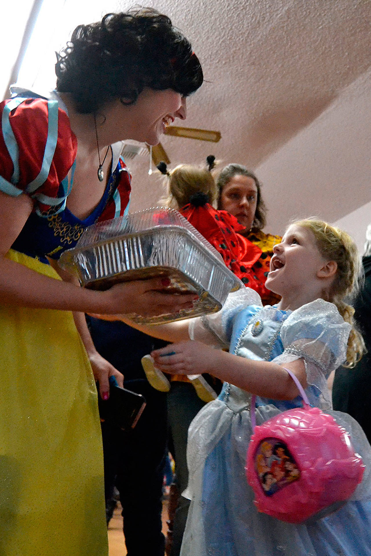Charissa Decker surprises her daughter Wren, 5, with a cake she won during the Cake Walk at the the Sequim Prairie Grange’s Country Fair on Oct. 27. Sequim Gazette photo by Matthew Nash