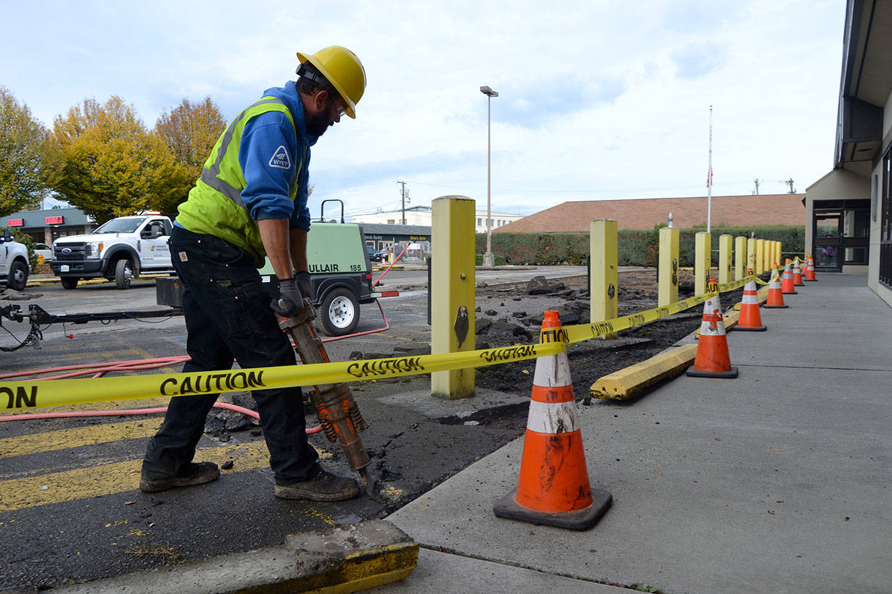 Colbi Bruni with Lakeside Industries jack hammers the old pavement in front of the Sequim Post Office on Halloween. He and other crewmen worked over two days to resurface the parking lot.