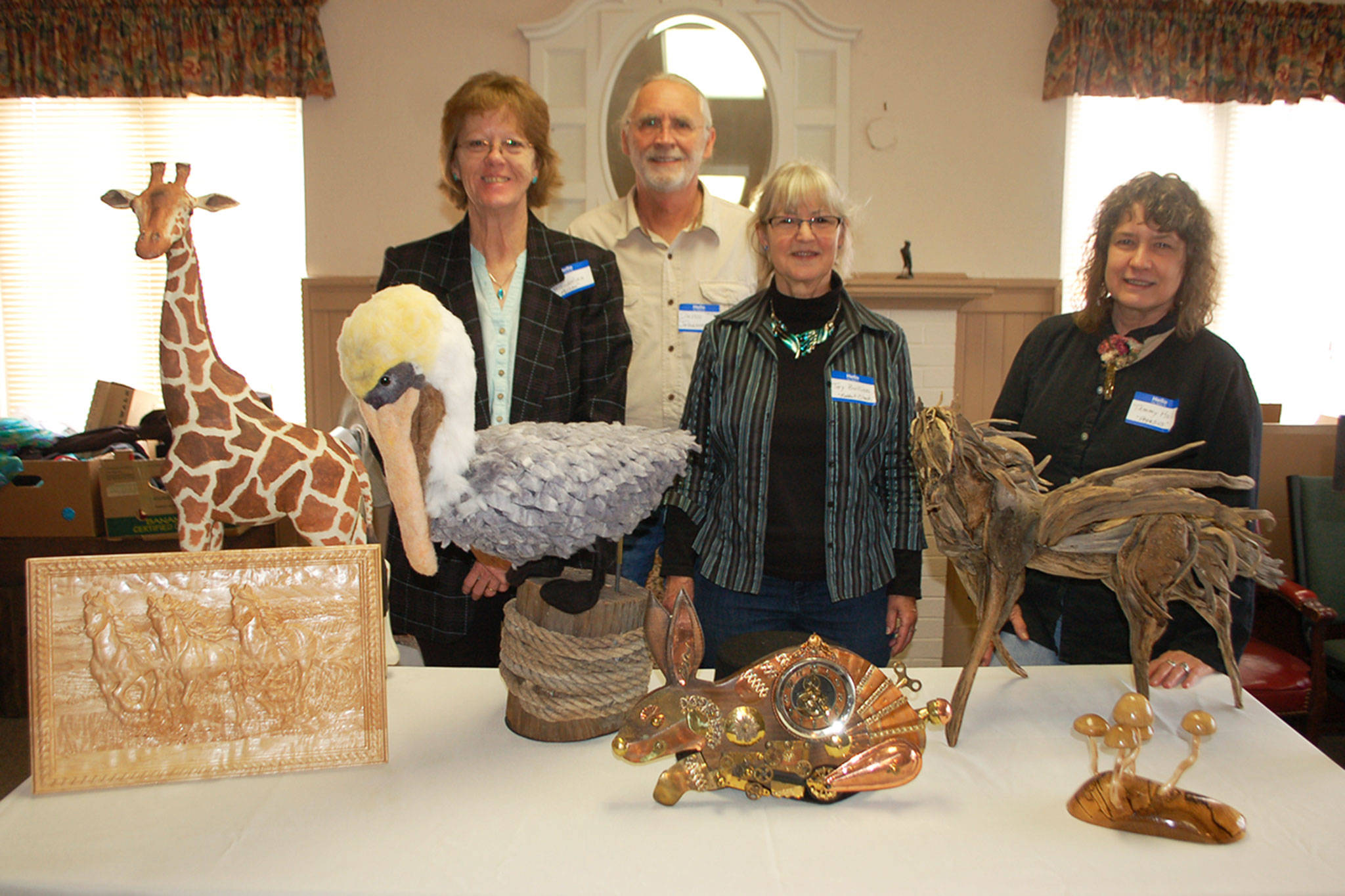 Olympic Theatre Arts sets the stage for “Heart for the Arts” an annual fundraiser that promotes a variety of artists in the Sequim community. A few of the live auction contributing artists, from left, are Terri Biondolino with “Hank”a pelican sculpture of felt fiber, David Johannessohn, Toy Buillon, with her and her husband Tim’s (not pictured) piece “Rabbit Clock” made from wood and random items, and Tammy Hall with her driftwood sculpture “Pegasus.” Sequim Gazette photo by Erin Hawkins