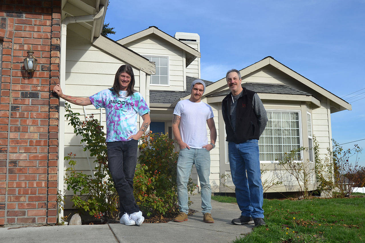 George Duncan, full-time volunteer for the Washington State Association of Oxford Houses, and residents Tyler Likkel and Jim Wasnock stand outside Oxford House Rainshadow in Sequim where six men live and share expenses and responsibilities as they work on recovery from substance abuse together. Sequim Gazette photo by Matthew Nash