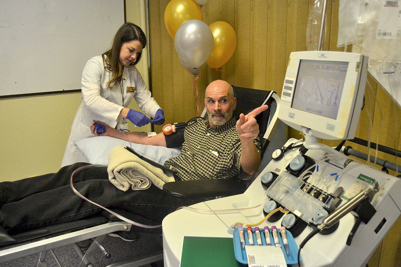 Doug Brundage follows the line as platelets are transferred for a donation for Bloodworks Northwest as Dominika Ujlaky, phlebotomist, readies for him the rest of the donation. So far, Brundage has donated 100 pints of blood and platelets and plans to continue giving. Sequim Gazette photo by Matthew Nash