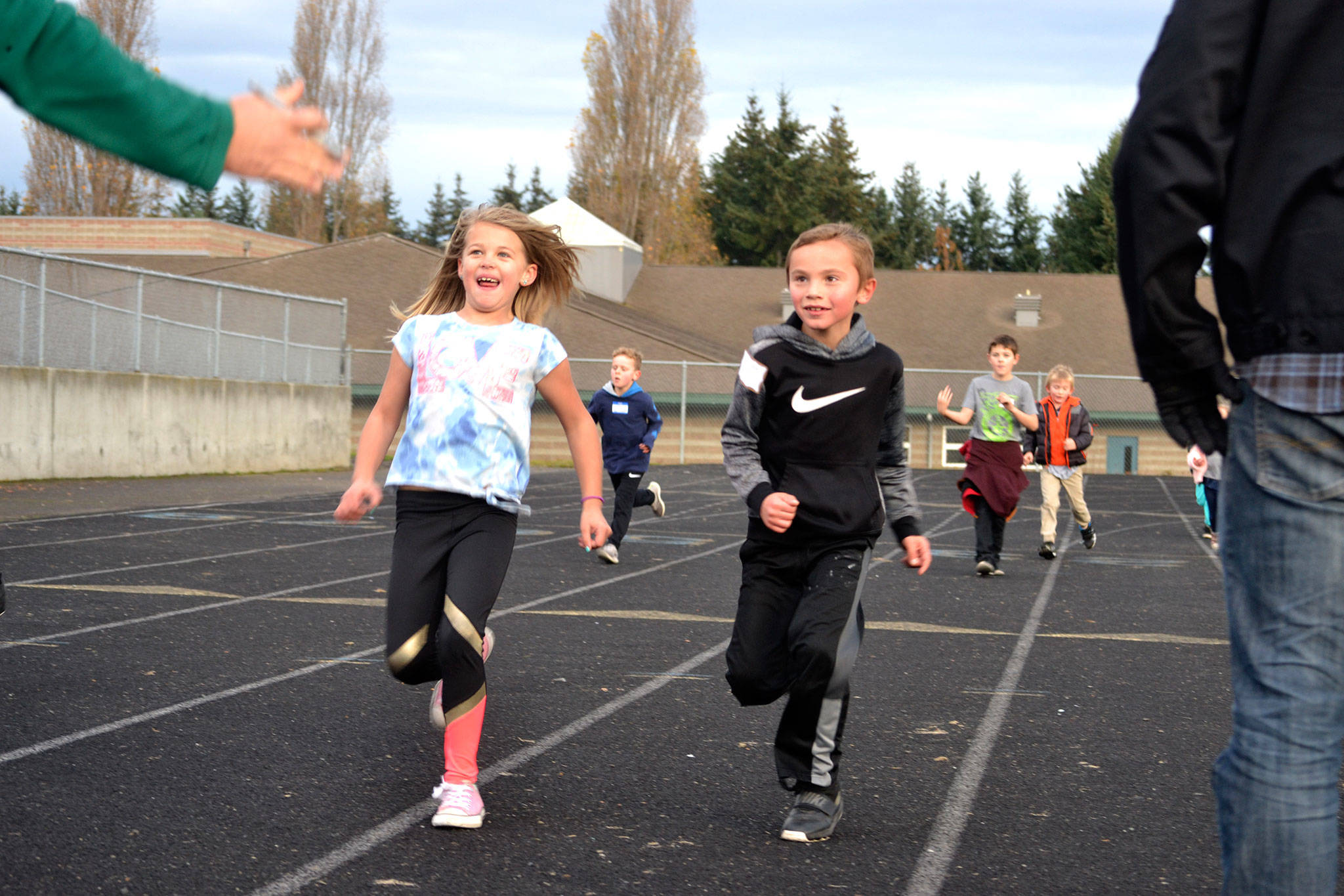Anella Henning and Carson Olsen run to a stop so their laps at Helen Haller Elementary’s Turkey Trot fundraiser can be counted. Sequim Gazette photo by Matthew Nash