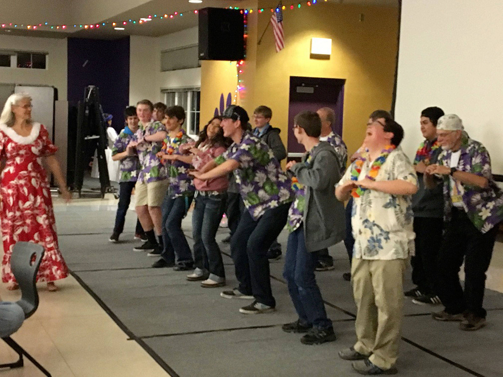 Team members of the Sequim High School Robotics Club, also known as the Sequim Robotics Federation, attempt to hula at last year’s luau for the team. The annual event, this year on Dec. 1, serves as its biggest fundraiser for competitions. Submitted photo