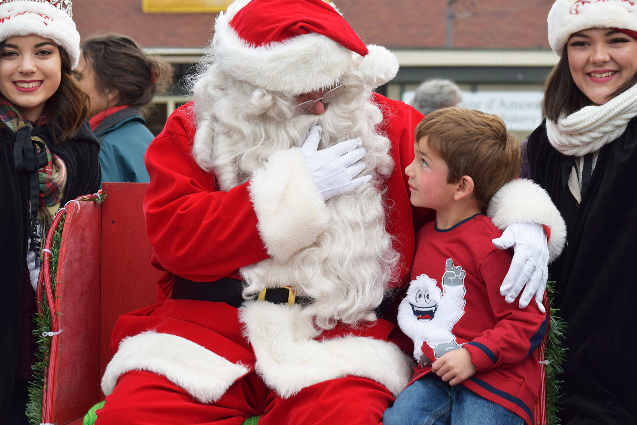 Santa Claus talks with Adrian Endicott, 5, as Sequim Irrigation Festival princesses Liliana Williams, left, and Gabi Simonson, right, look on during Home Town Holidays at the corner of Sequim Avenue and Washington Street on Nov. 24. Sequim Gazette photos by Erin Hawkins