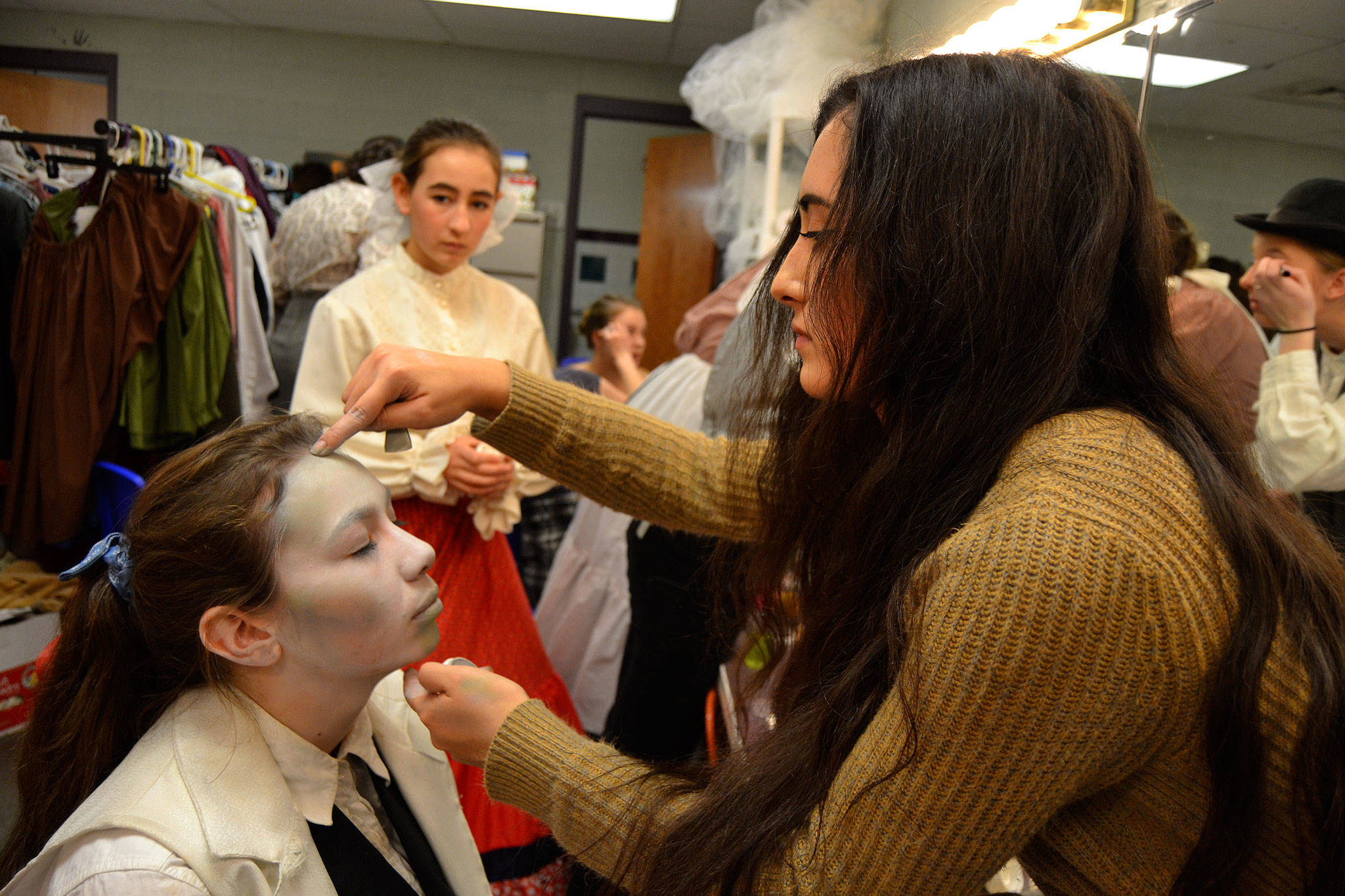 Corrine Klinger, makeup chair, readies Maggie van Dyken’s makeup for her role as Jacob Marley as Kariya Johnson watches. Students say they’re excited to reveal the looks for the all of the ghosts in “A Christmas Carol.” Sequim Gazette photo by Matthew Nash