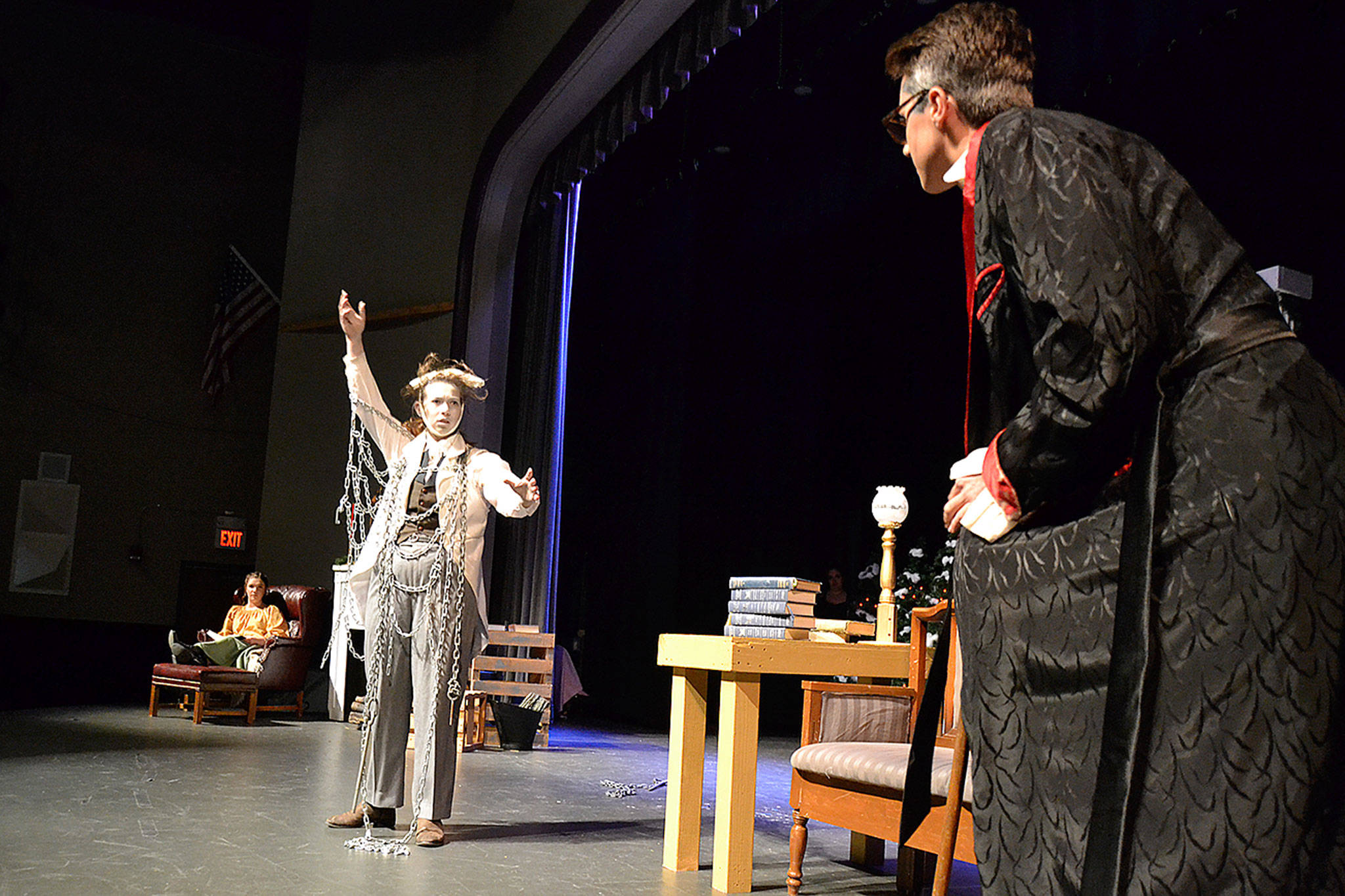 Jacob Marley (Maggie van Dyken) confronts Ebenezer Scrooge (Damon Little) with narrator Payton Sturm watching in his home warning him about ghosts coming to visit him in Sequim High School’s production of “A Christmas Carol.” Sequim Gazette photo by Matthew Nash
