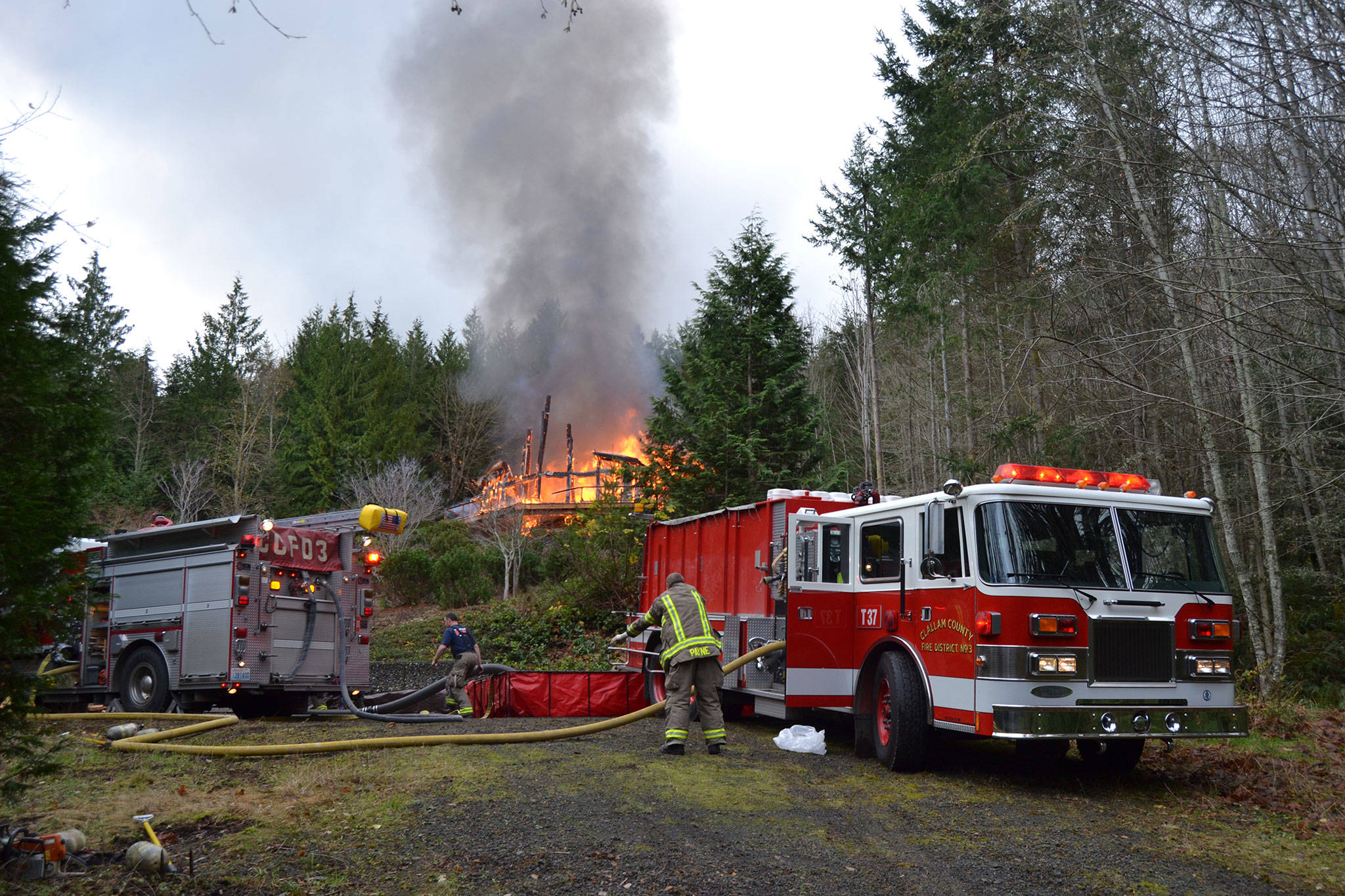 A fire on Monday morning burns on Howard Heights Road east of Sequim. Clallam County Fire District 3 officials report steep conditions made it difficult to get water to the home.