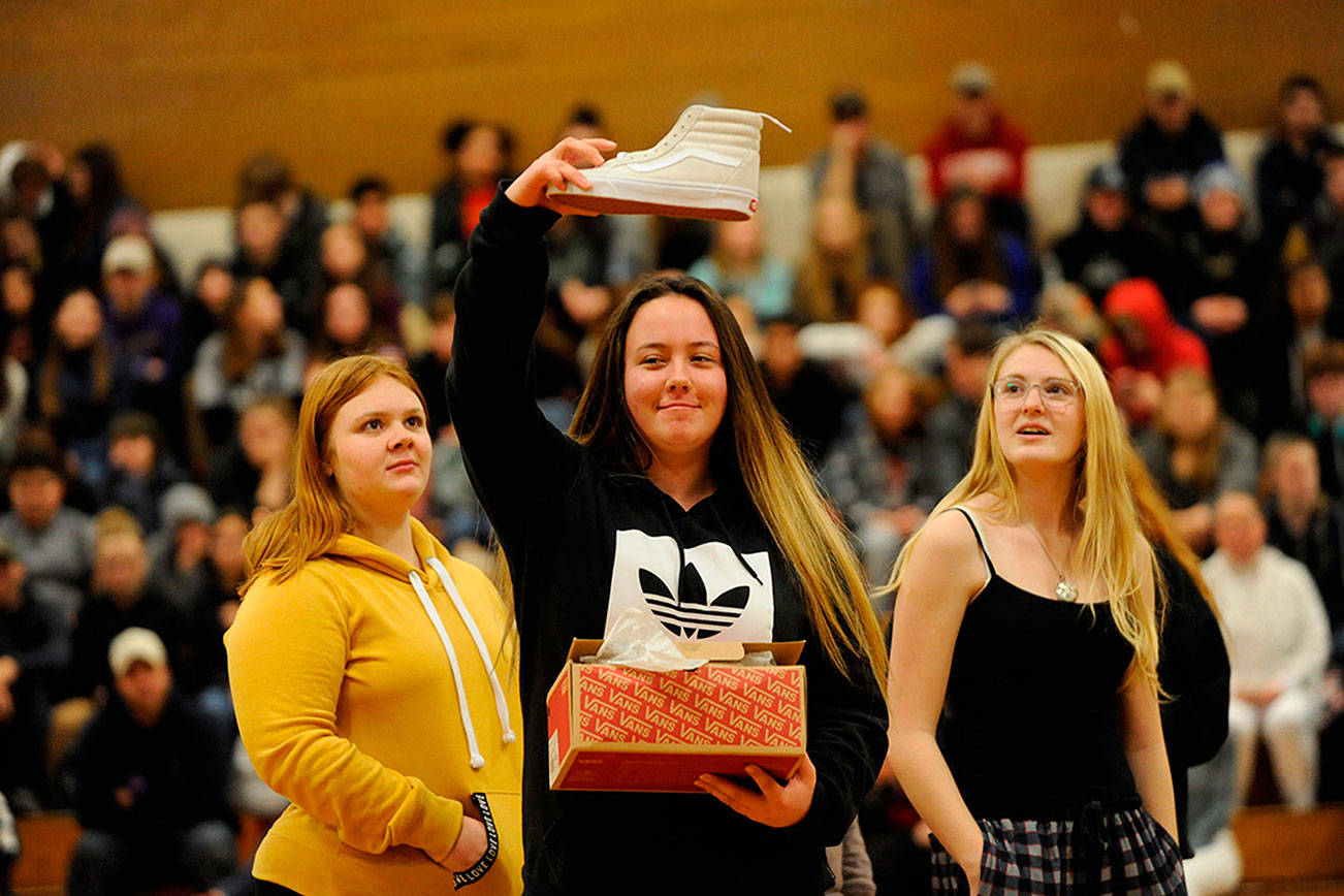 Samantha White shows her new kicks to the crowd she received from one of Sonja Miller’s classes as a gift during the Winter Wishes assembly on Dec. 19. White said the shoes were “fresh.” Sequim Gazette photo by Matthew Nash