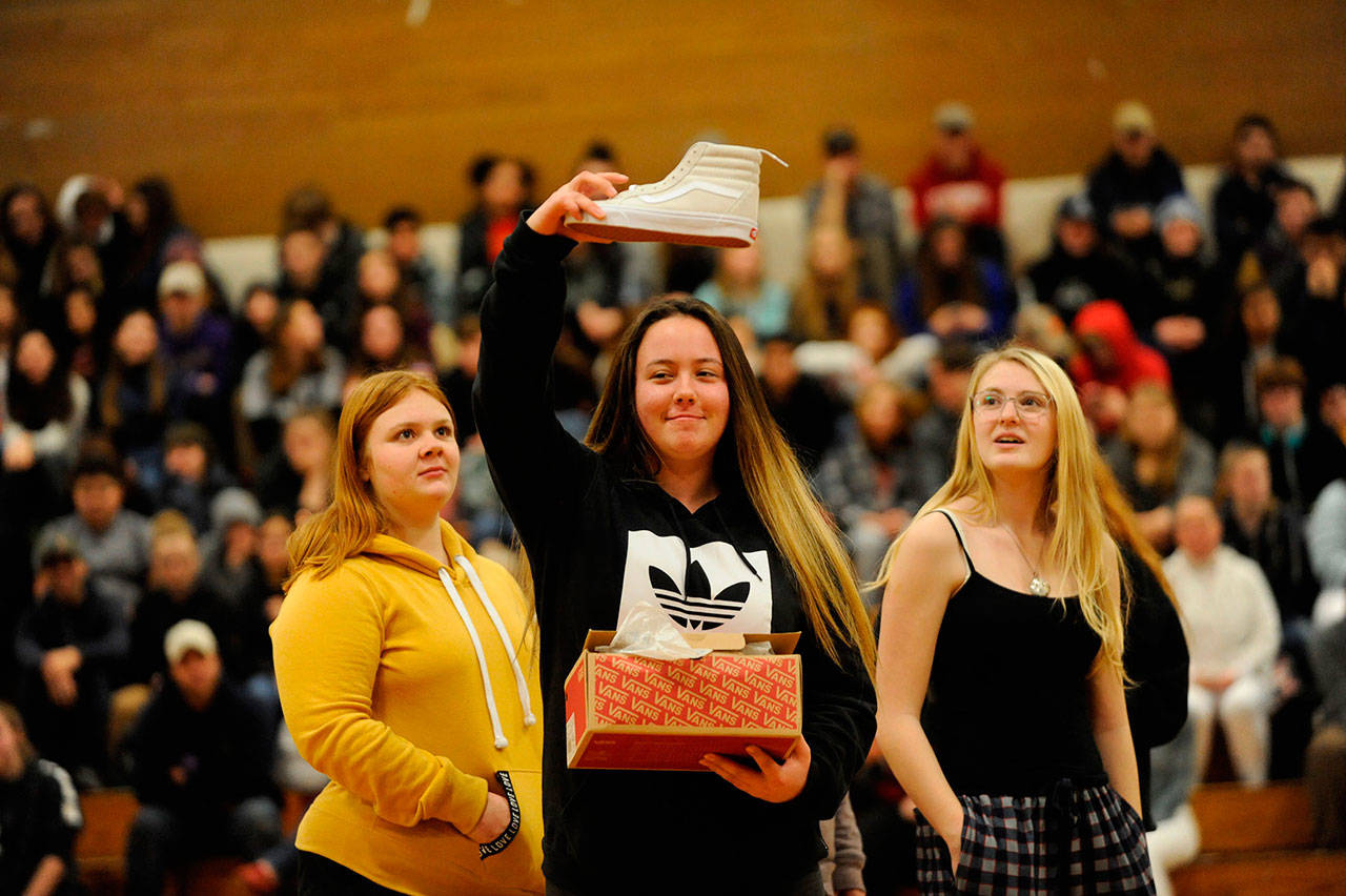 Samantha White shows her new kicks to the crowd she received from one of Sonja Miller’s classes as a gift during the Winter Wishes assembly on Dec. 19. White said the shoes were “fresh.” Sequim Gazette photo by Matthew Nash