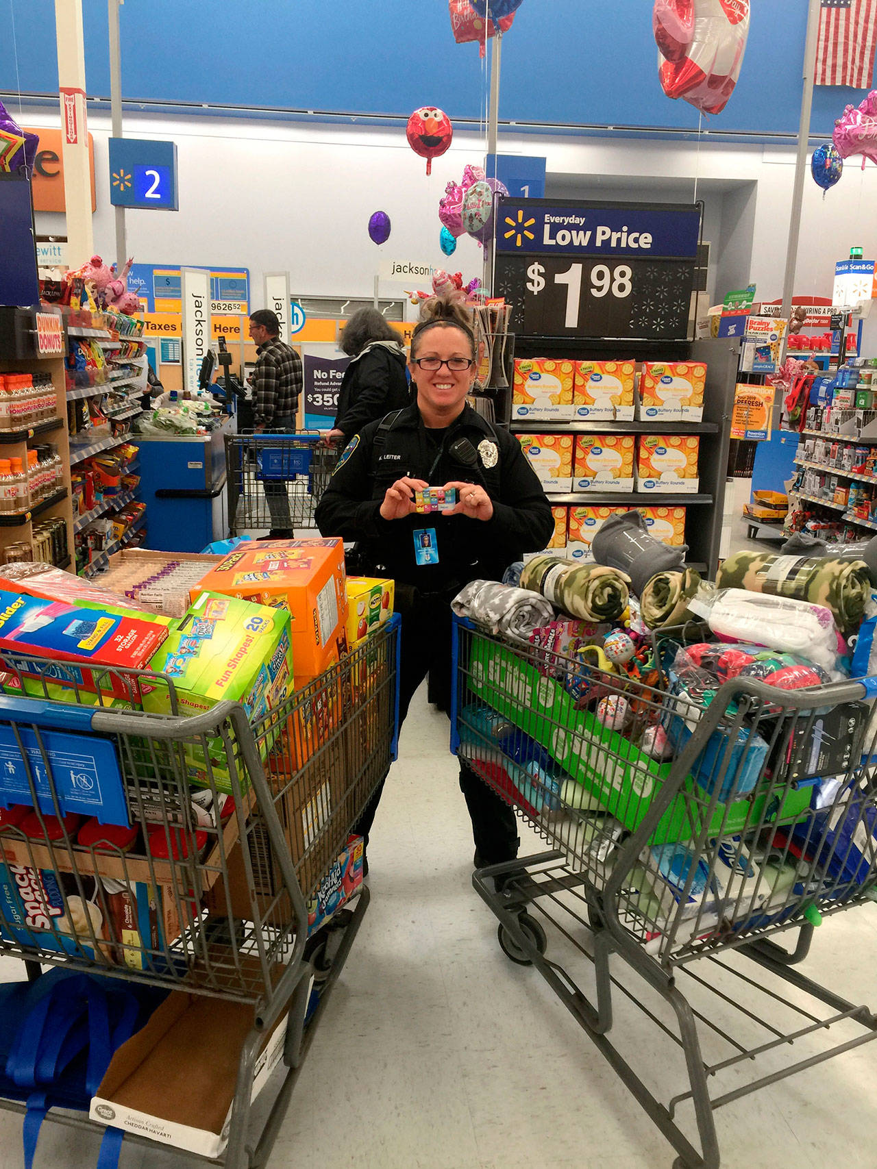 Sequim School Resource Officer Kindryn Leiter stands ready to check out with a $1,500 grant/gift card to Walmart for supplies to help in-need Sequim students. Photo courtesy of City of Sequim