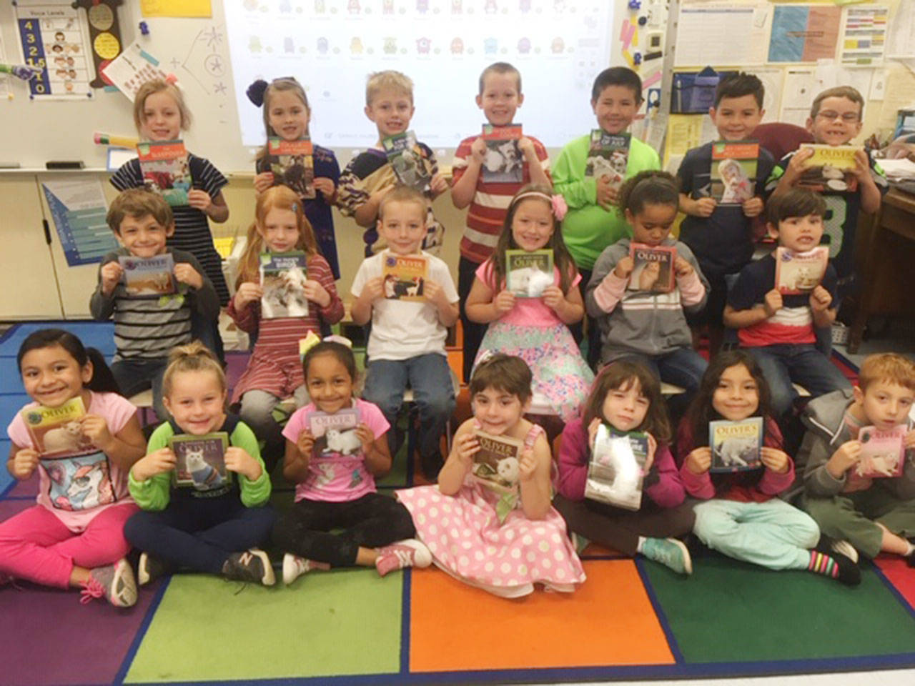 First-graders from Christine MacDougall-Danielson’s class enjoy “Oliver the Cat” books, thanks a community education grant through Beta Nu Chapter of Delta Kappa Gamma. Submitted photo