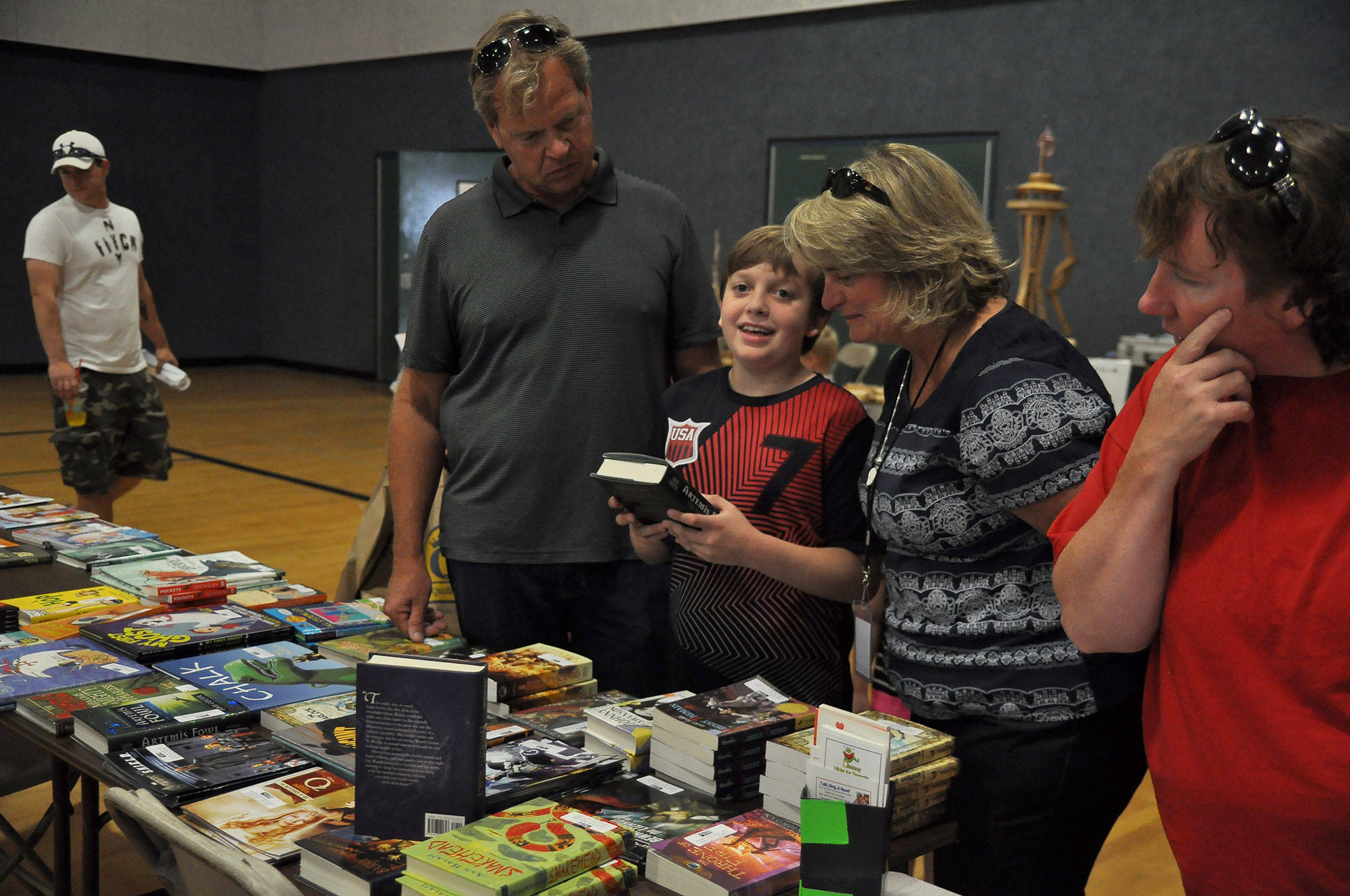 The Bowden family looks at Jonathan’s new book he received from Sequim’s Back to School Fair provided by the Clallam County Literacy Council. Volunteers setup at close to a dozen events like this each year to promote reading. Sequim Gazette file photo by Michael Dashiell
