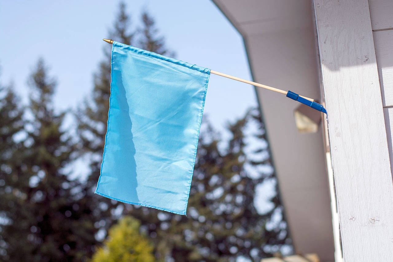 A blue flag posted outside Serenity House of Clallam County’s night-by-night shelter lets people know the shelter is open 24/7. (Jesse Major/Peninsula Daily News)
