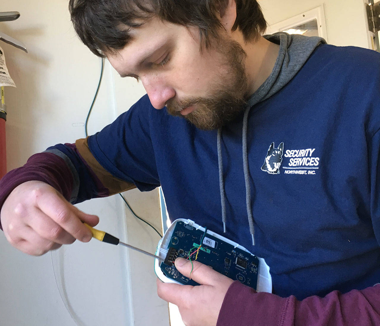 Sevi Kovach, a security system technician with Security Services Northwest, works to install a system donated to the Sequim Food Bank. Photo courtesy of Security Services Northwest, Inc.