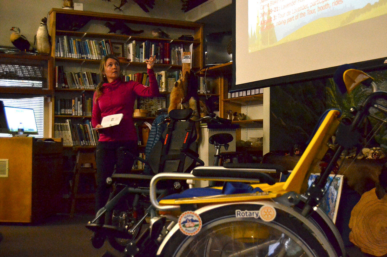 Nicole Lepping, founder and president of Sequim Wheelers, reveals the second new bike, the 2019 Opair adaptive wheelchair bicycle, on left, to volunteers on April 3 in the Dungeness River Audubon Center. Last year, volunteers gave 90 rides in 15 weeks on the 2018 Duet bike, on right. This year, volunteers plan up to four months of free rides for those unable to ride a bicycle. Sequim Gazette photo by Matthew Nash
