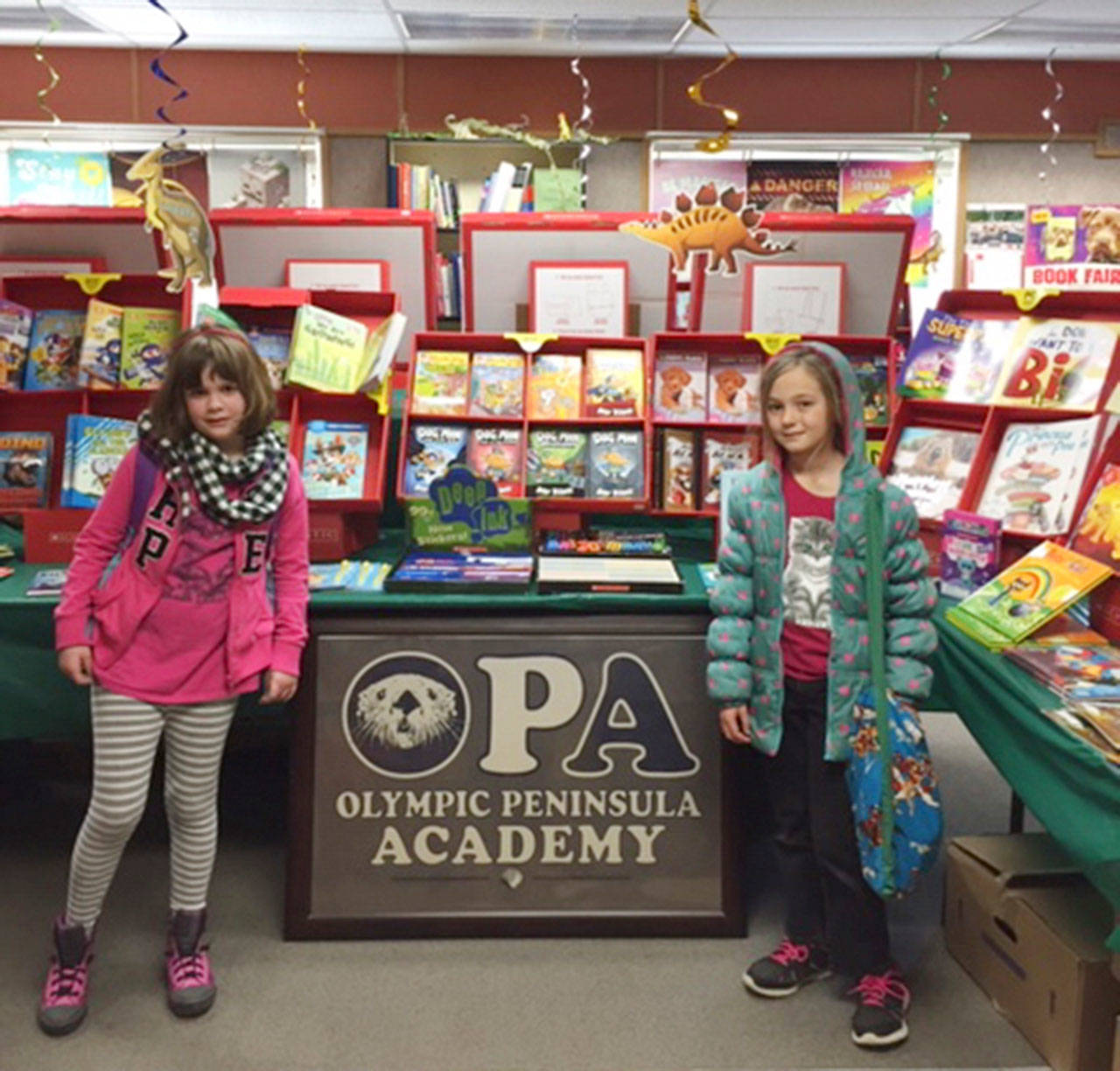 Olympic Peninsula Academy second-graders Gabby Terry and Josephine Johnson take part in OPA’s Scholastic Book Fair. Submitted photo
