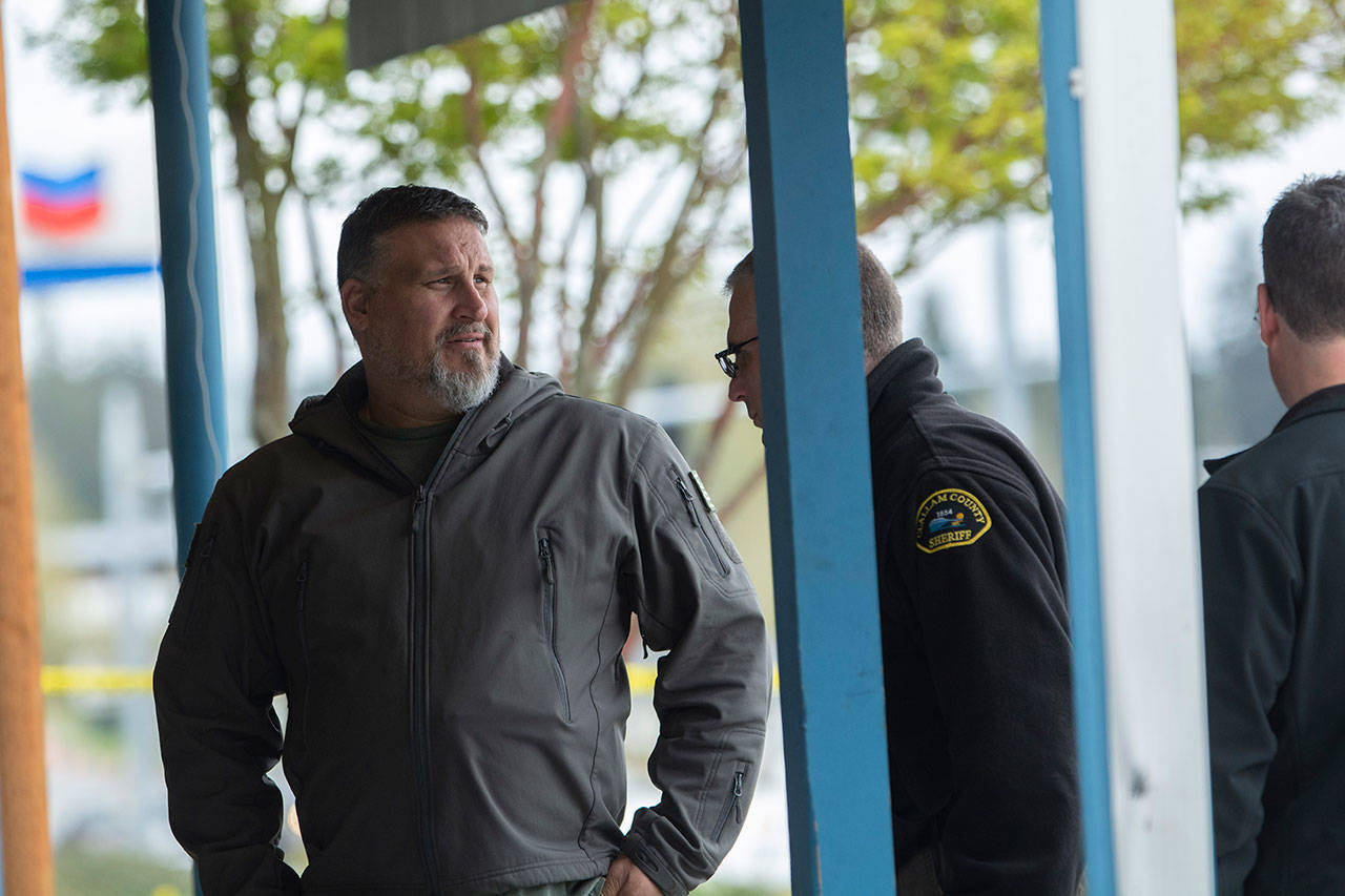 FREDS Guns owner Seth Larson talks to Clallam County Sheriff’s detectives after someone drove a loader through his store and stole about 20-30 handguns. (Jesse Major/Peninsula Daily News)