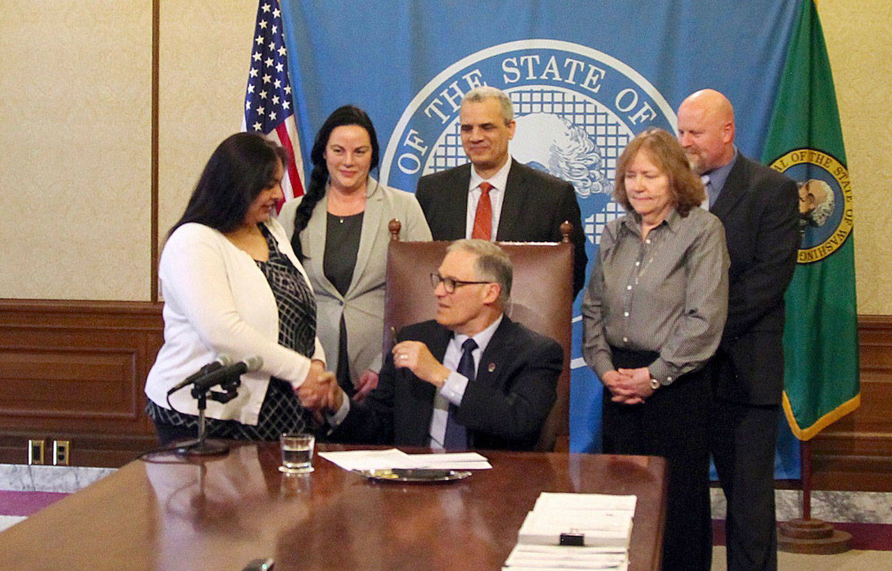 Gov. Jay Inslee signs Sen. Manka Dhingra’s bill April 17. The bill requires information to be provided to felons on their voting rights after being released from custody. Photo by Emma Epperly/WNPA Olympia News Bureau