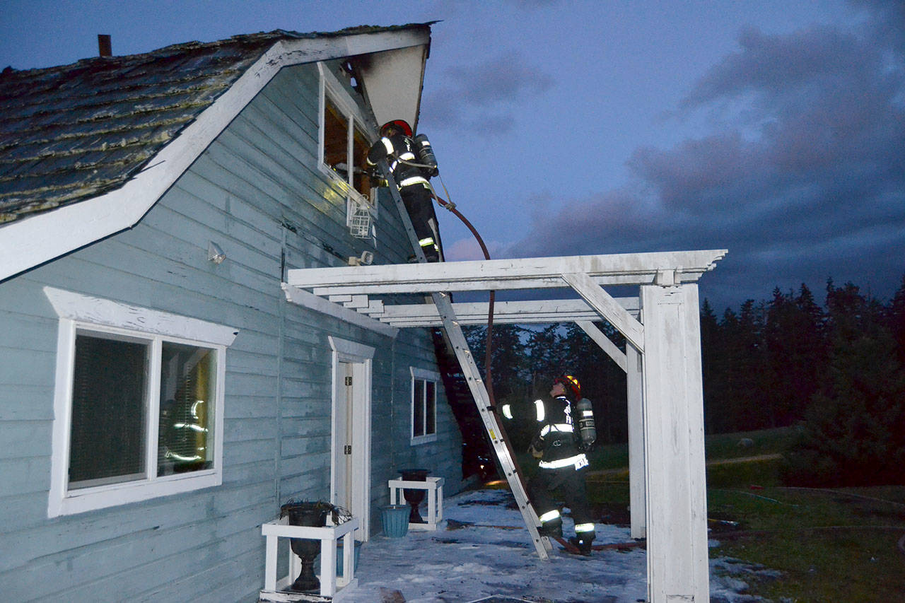 Port Ludlow Fire and Rescue firefighters look for hotspots on Friday night in a Gardiner home on the 2000 block of Old Gardiner Road. Sequim Gazette photo by Matthew Nash