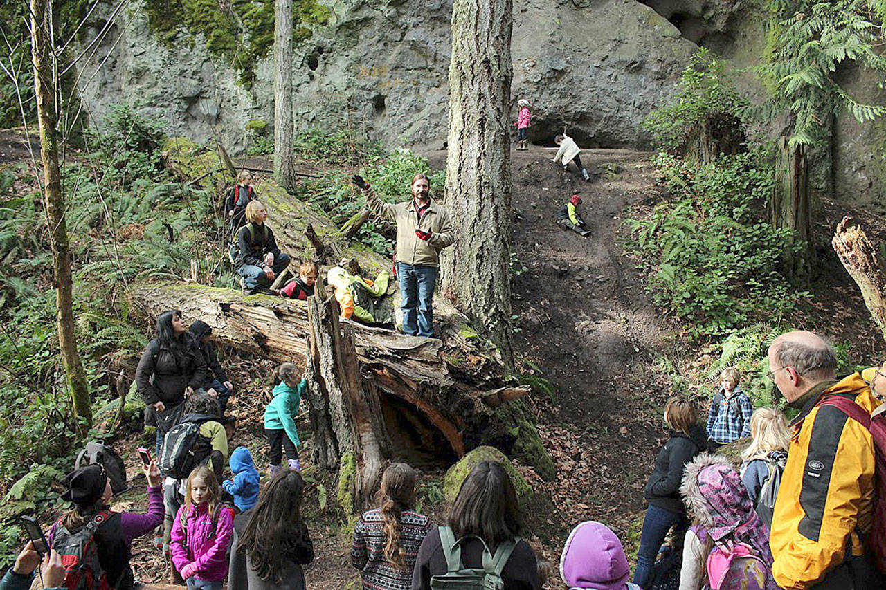 David Brownell of the Jamestown S’Klallam Tribe uses an old log as a podium to instruct Windward School students during a recent field trip to Tamanowas Rock. Submitted photo