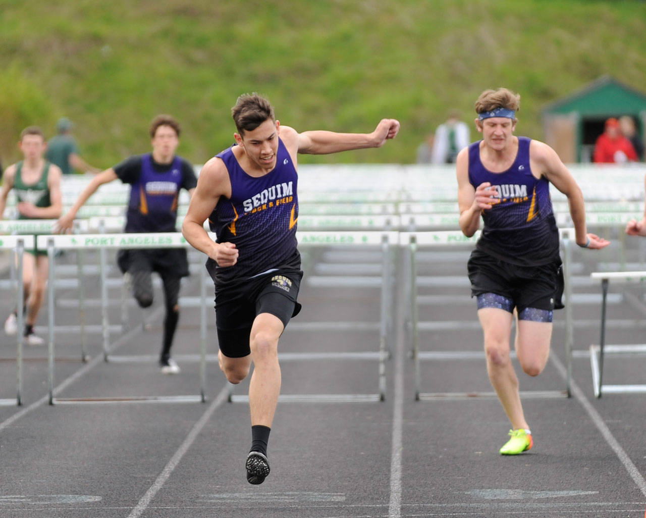 Sequim’s Riley Martin, center, edges teammate Fischer Jensen, right, at the finish line of the 110 high hurdles on April 25 in Port Angeles. Sequim Gazette photo by Michael Dashiell