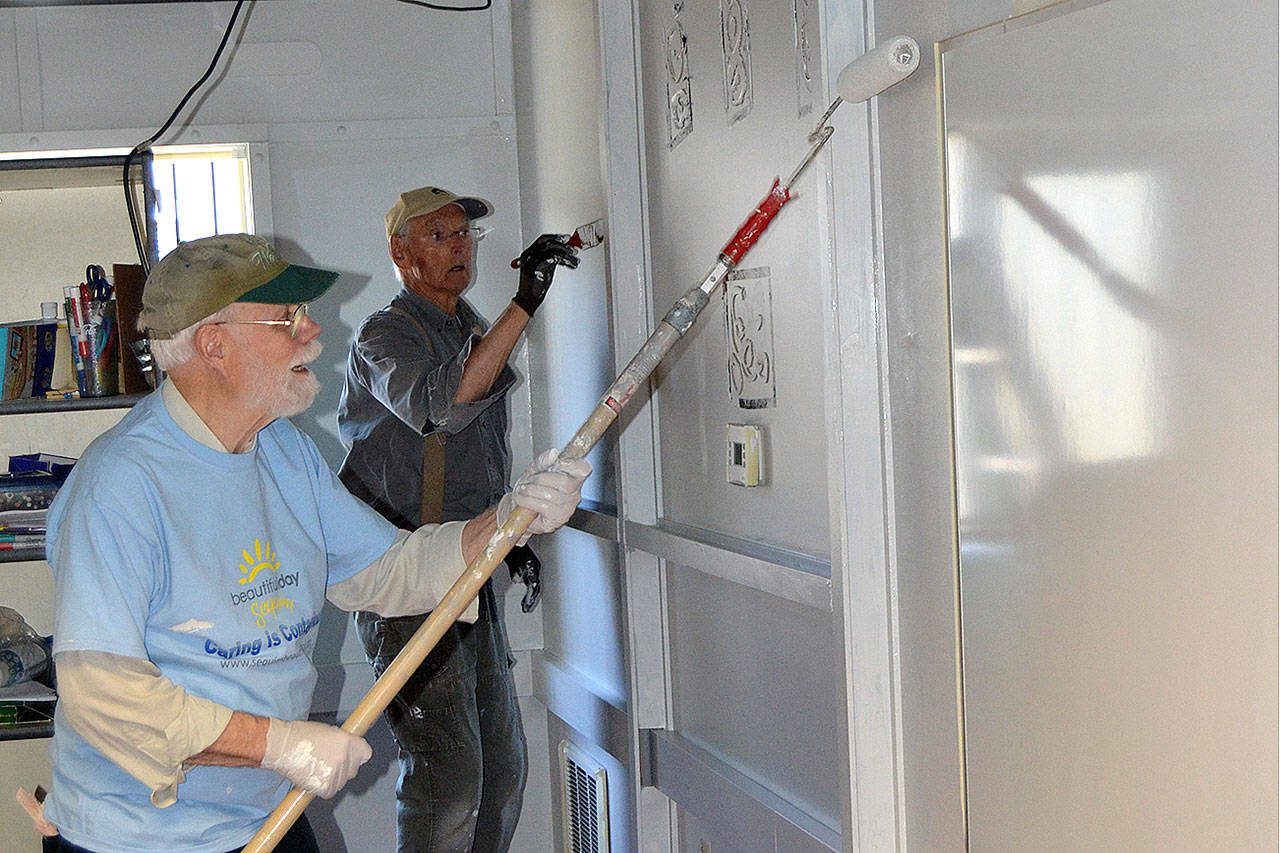 Mark McGriff, on left, with the Sequim Worship Center, and Al Bierlink with Sequim Community Church, help paint a classroom at Olympic Peninsula Academy’s new portables as part of Sequim Beautiful Day, a community effort to provide service. Sequim Gazette photo by Matthew Nash