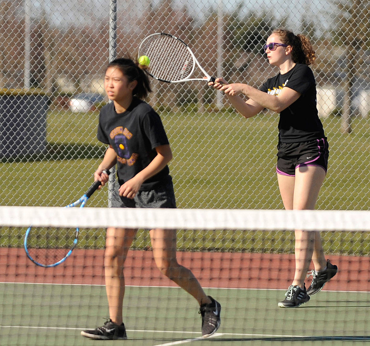 Sequim’s Arlene Law, right, returns a volley as she and doubles partner Amanda He take on a Kingston doubles team in March. Law and He survived a three-set battle in the opening round of the Olympic League tournament on May 9, coming back from a 5-1 deficit in the third set to win the next six points. Sequim Gazette file photo by Michael Dashiell