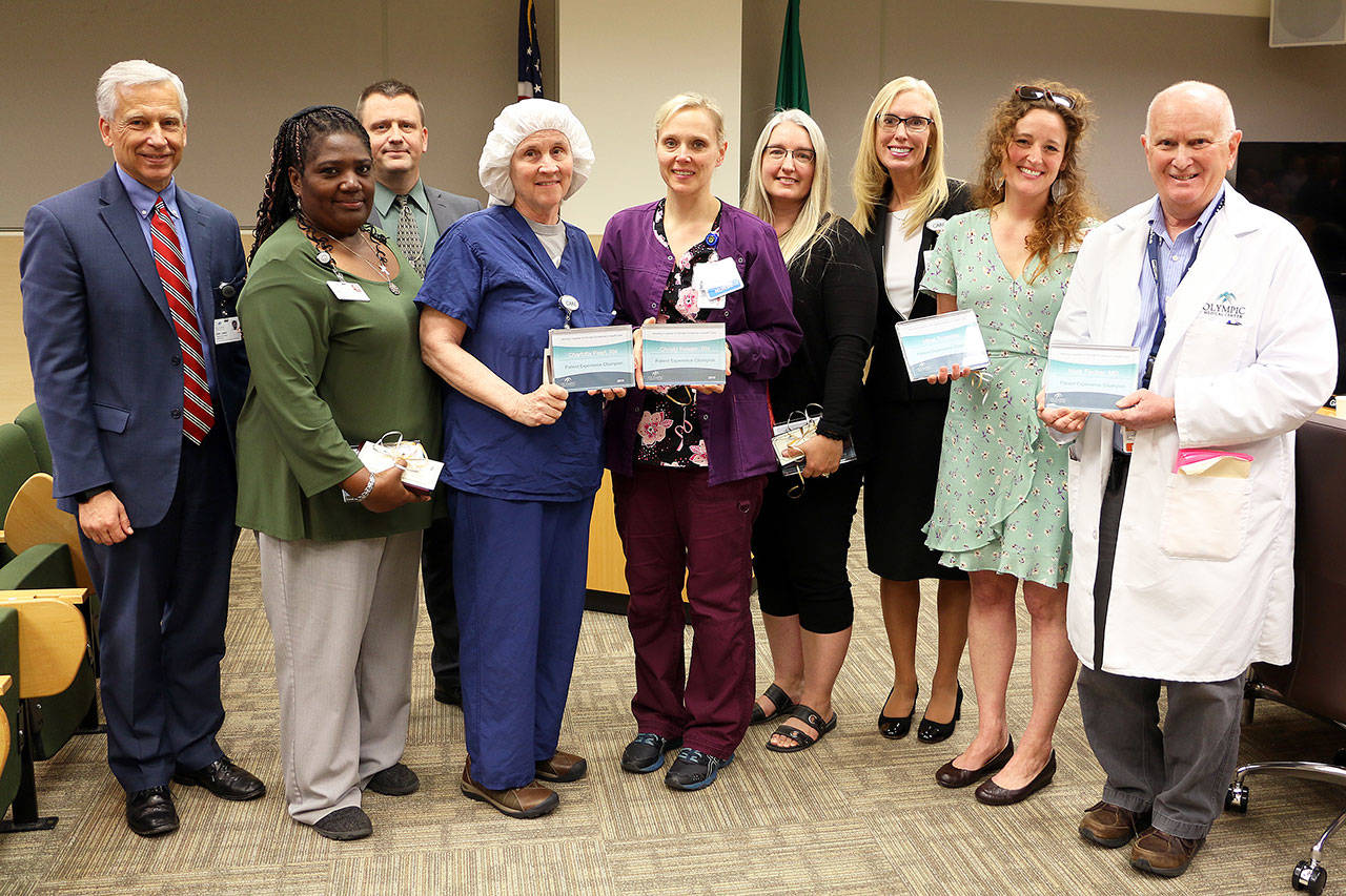 Pictured, from left, are Olympic Medical Center CEO Eric Lewis; Patient Access Representative Lisa Glynn; board president John Nutter; OR clinical educator Ellen Adams (who accepted an award on behalf of RN Charlotta Pearl); Katrin Junghanns, director of ICU/Telemetry, who accepted the award on behalf of RN Christy Ressor; Holly Heustis, Clinic Supervisor of OMP Primary Care; Jennifer Burkhardt, Olympic Medical Center’s Chief Human Resources Officer and General Counsel; Mikel Townsley, Patient Navigator for Olympic Medical Cancer Center, and Dr. Mark Fischer. Photo courtesy of Olympic Medical Center