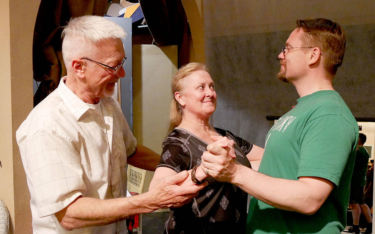 Director Greg Scherer, left, uses his classical dance background to coach Cheryl DiPietro and Michael Sickles in a waltz. Photo courtesy of Olympic Theatre Arts