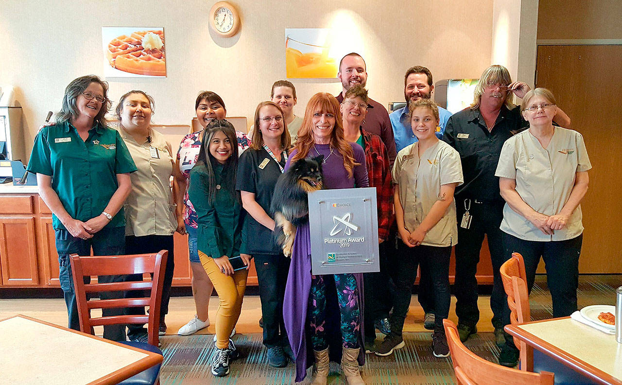 Staff members at Quality Inn & Suites at Olympic National Park join general manager Nancy Merrigan, center, in celebrating the hotel’s 2019 Platinum Award. Submitted photo