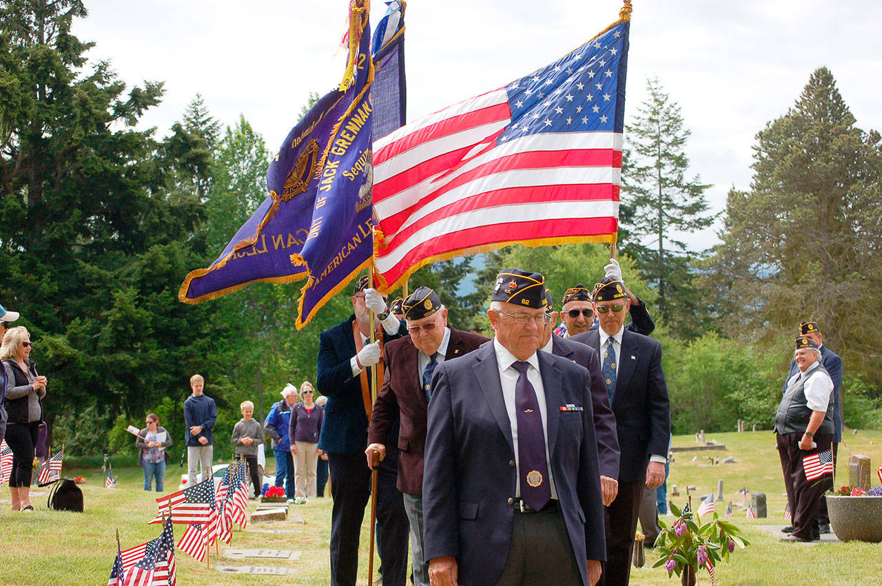 Members of Jack Grennan Post 62 of the American Legion lead with a series of flags at the Memorial Day ceremony at Sequim View Cemetery in 2018. Sequim Gazette file photo by Erin Hawkins
