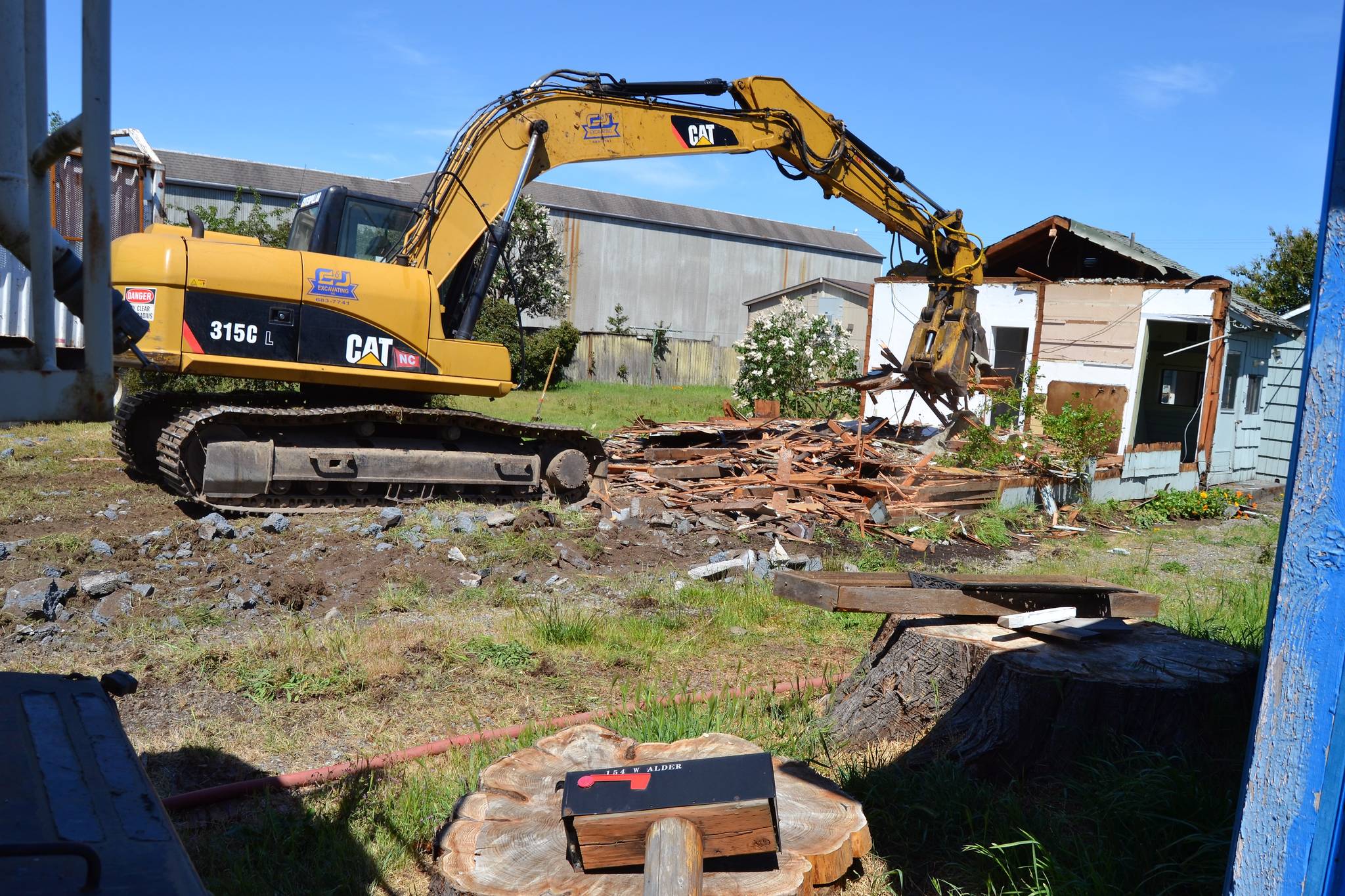 Crewmen with C&J Excavating demolish a home at 154 W. Alder St. on May 23 to make room for parking and potentially a new facility for the Sequim Food Bank. Facility organizers said they welcome input on the future of the Food Bank by 360-681-1205 or 360-461-6038. Sequim Gazette photo by Matthew Nash