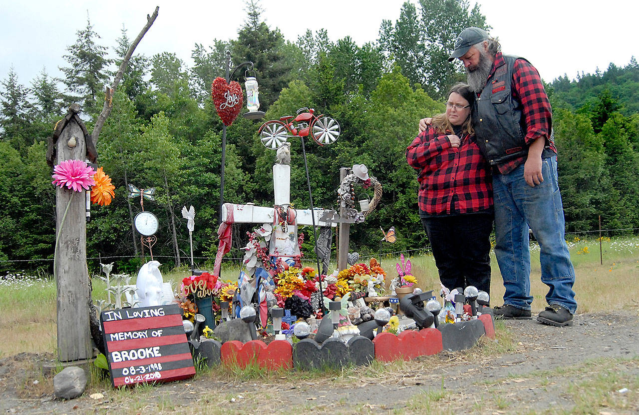 Kim and Don Bedinger look over a roadside memorial that was erected in memory of their 19-year-old daughter, Brooke, who was killed while riding her motorcycle near the spot where U.S. Highway 101 crosses Morse Creek east of Port Angeles. (Keith Thorpe/Peninsula Daily News)