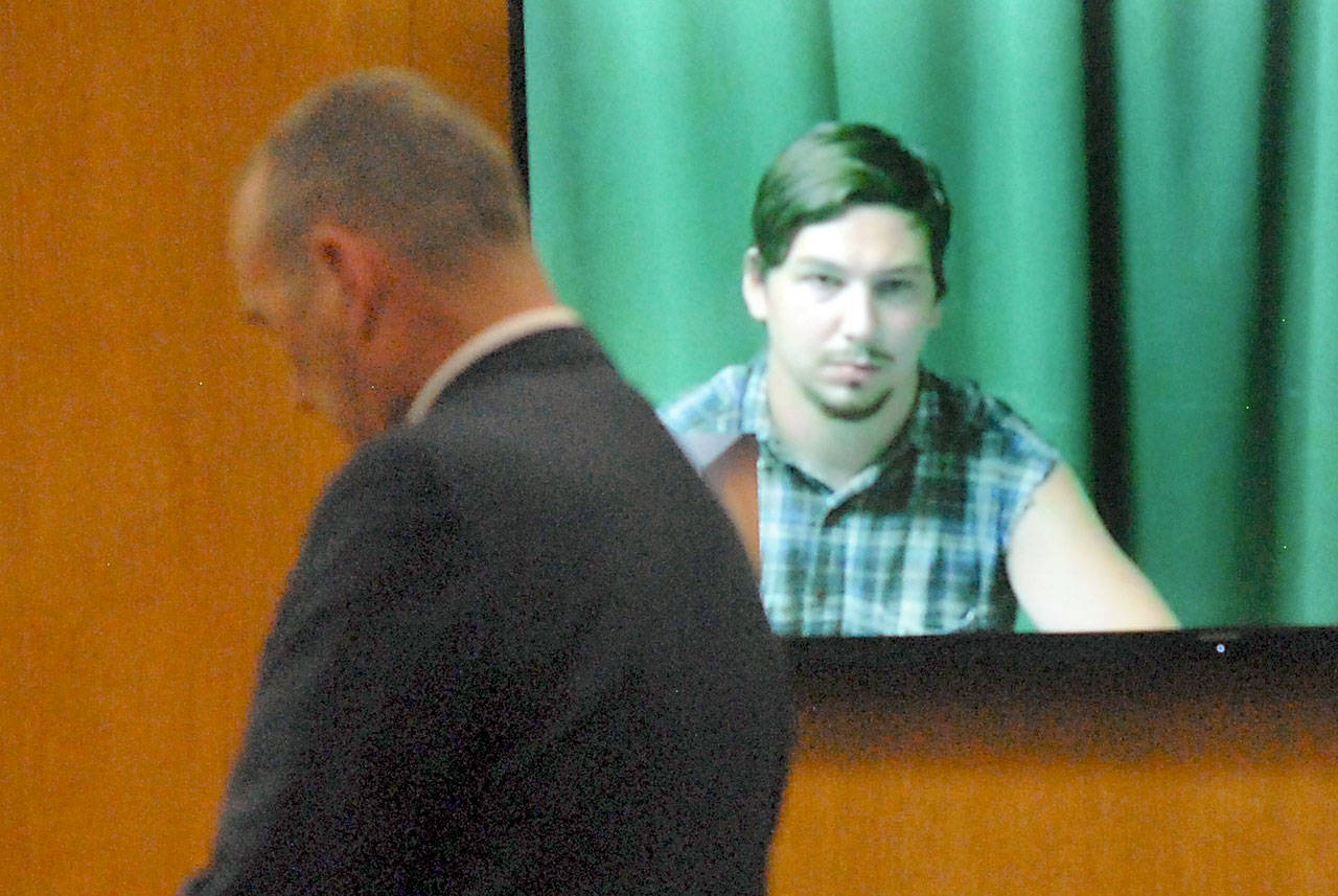 John R. Sutton, on video screen, makes his first appearance in Clallam County Superior Court on Thursday as his attorney, William Payne, appears on his behalf. (Keith Thorpe/Peninsula Daily News)