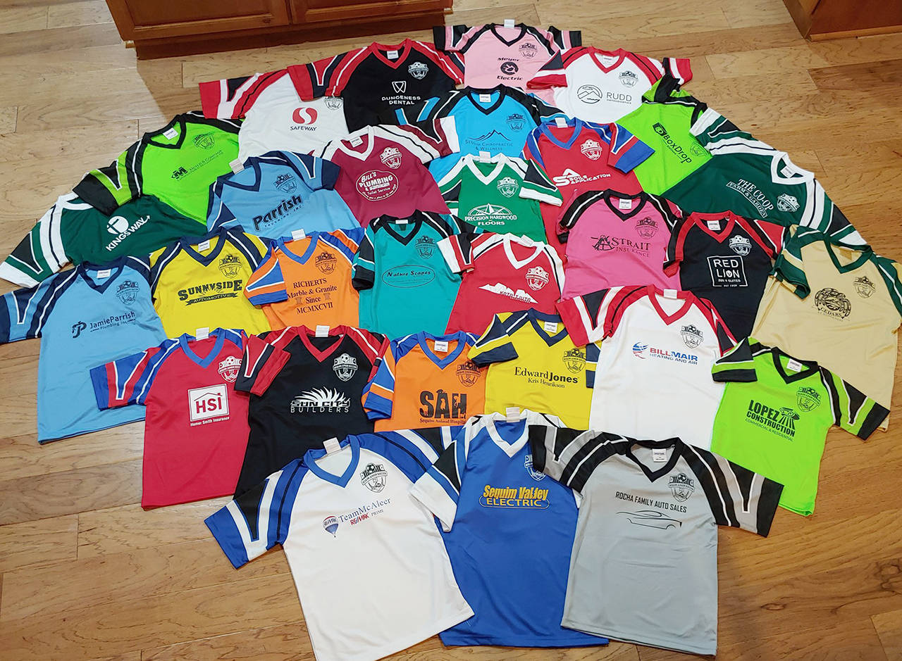Sequim Junior Soccer’s team shirts are displayed, showing various local sponsorships. Photo provided by David Henderson.