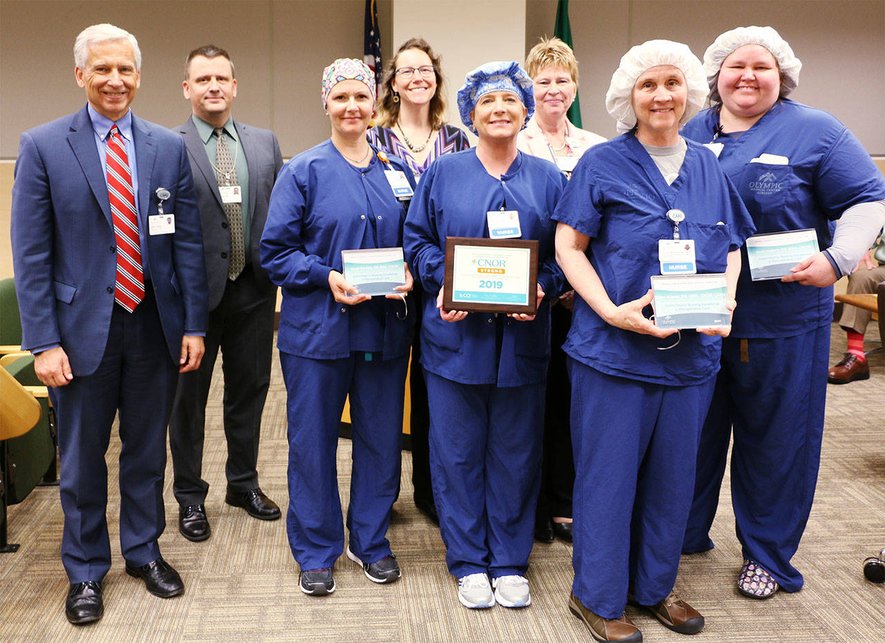 Pictured, from left, are Olympic Medical Center CEO; board president John Nutter; surgical services supervisor/RN Sarah Winfield; RN DeAnn Pype; operating room manager/RN Joellyn Jensen; Lorraine Wall, RN/chief nursing officer and hospital chief operating officer; clinical educator/RN Ellen Adams, and RN Heidi Mattern. Photo courtesy of Olympic Medical Center