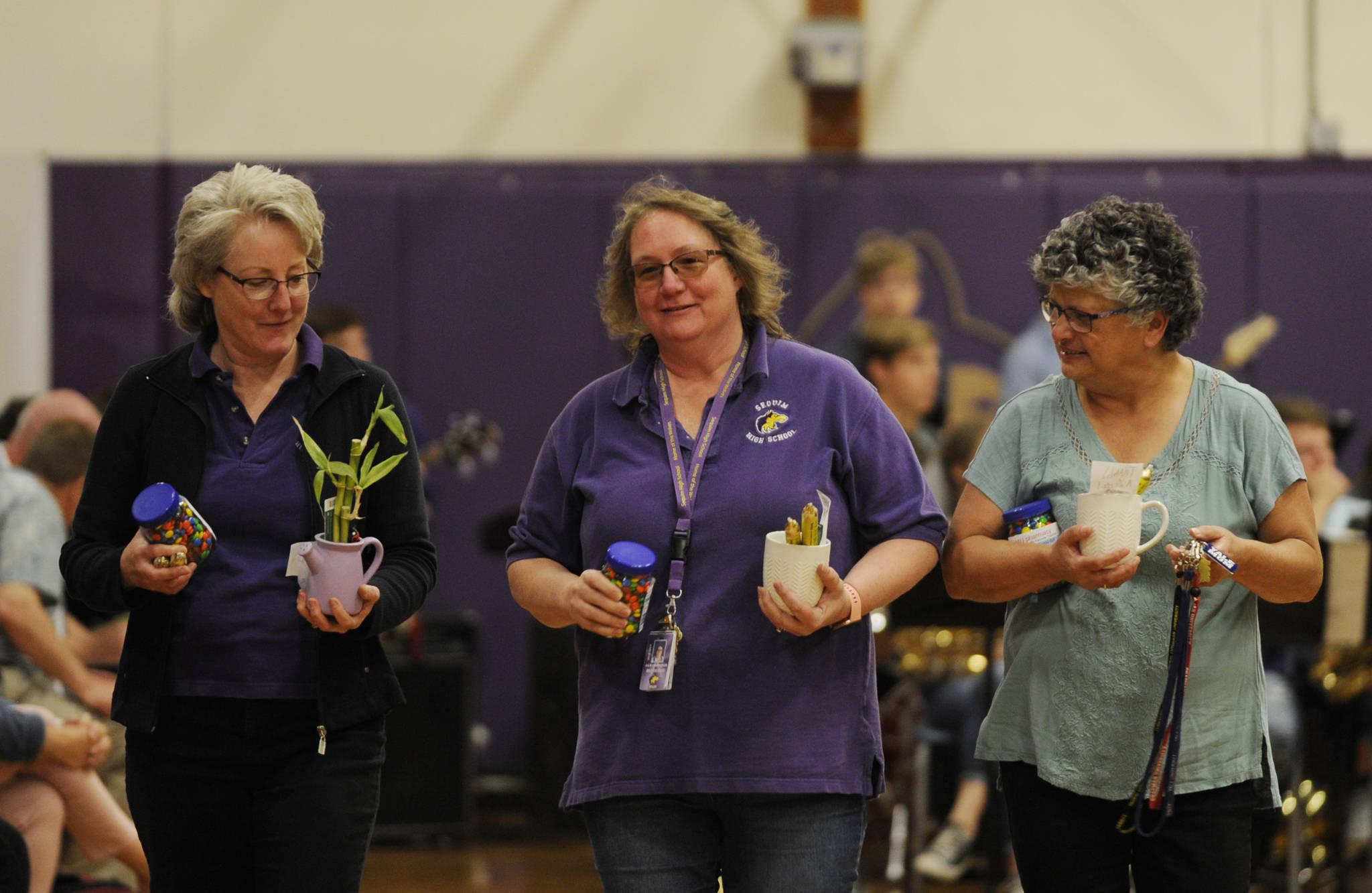 Sequim High office staff (from left) Erin Ulm, Julie Lancheros and Ann Tjemsland receive treats from graduating seniors at a Senior Recognition Assembly on May 31. Sequim Gazette photo by Michael Dashiell