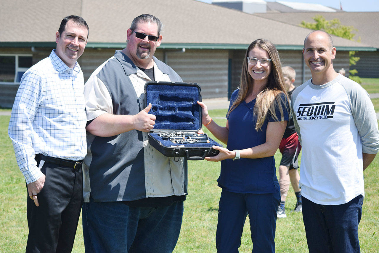 Former Sequim Middle School student Carly Swingle donates a clarinet to the SMS program. Pictured, from left, are Dr. Mathew Niemeyer at NW Eye Surgeons (Swingle’s employer), SMS band director George Rodes, Swingle and SMS principal Vince Riccobene. Submitted photo