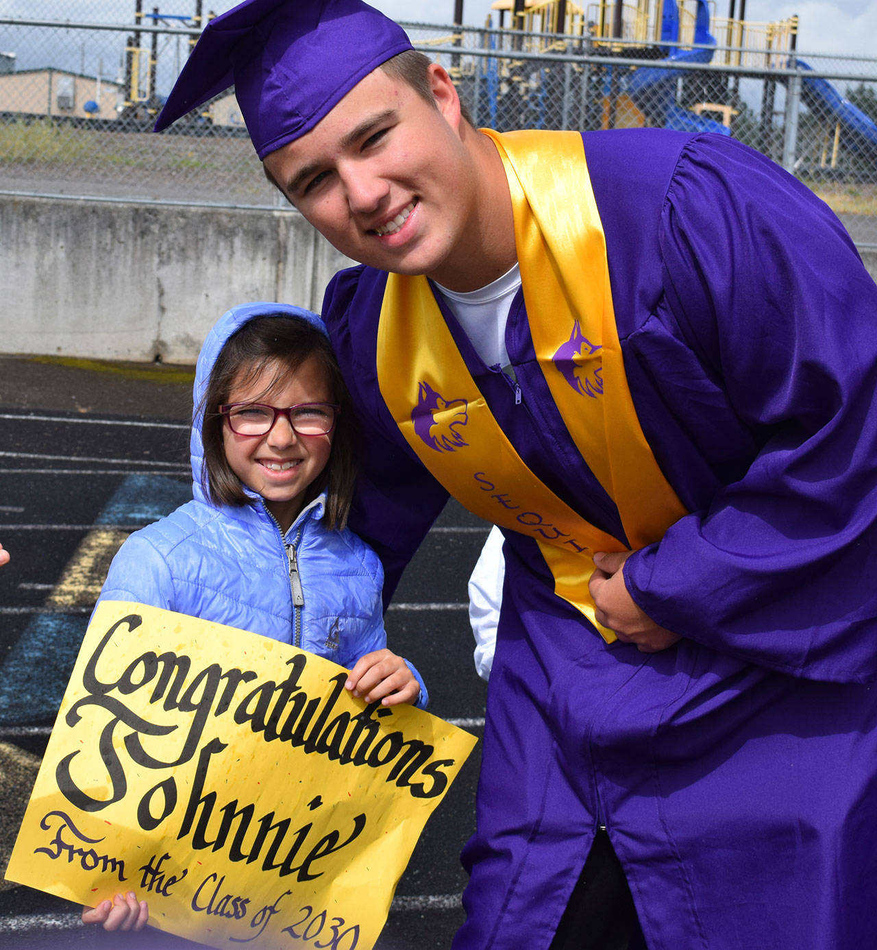 Sequim High School graduate-to-be Johnnie Young gets encouragement from Camryn Corbin, a first-grader in Kelly Miller’s Helen Haller Elementary School class, during the Graduation Walk event on June 7. Young graduated later that day at SHS’s commencement ceremony. Submitted photo