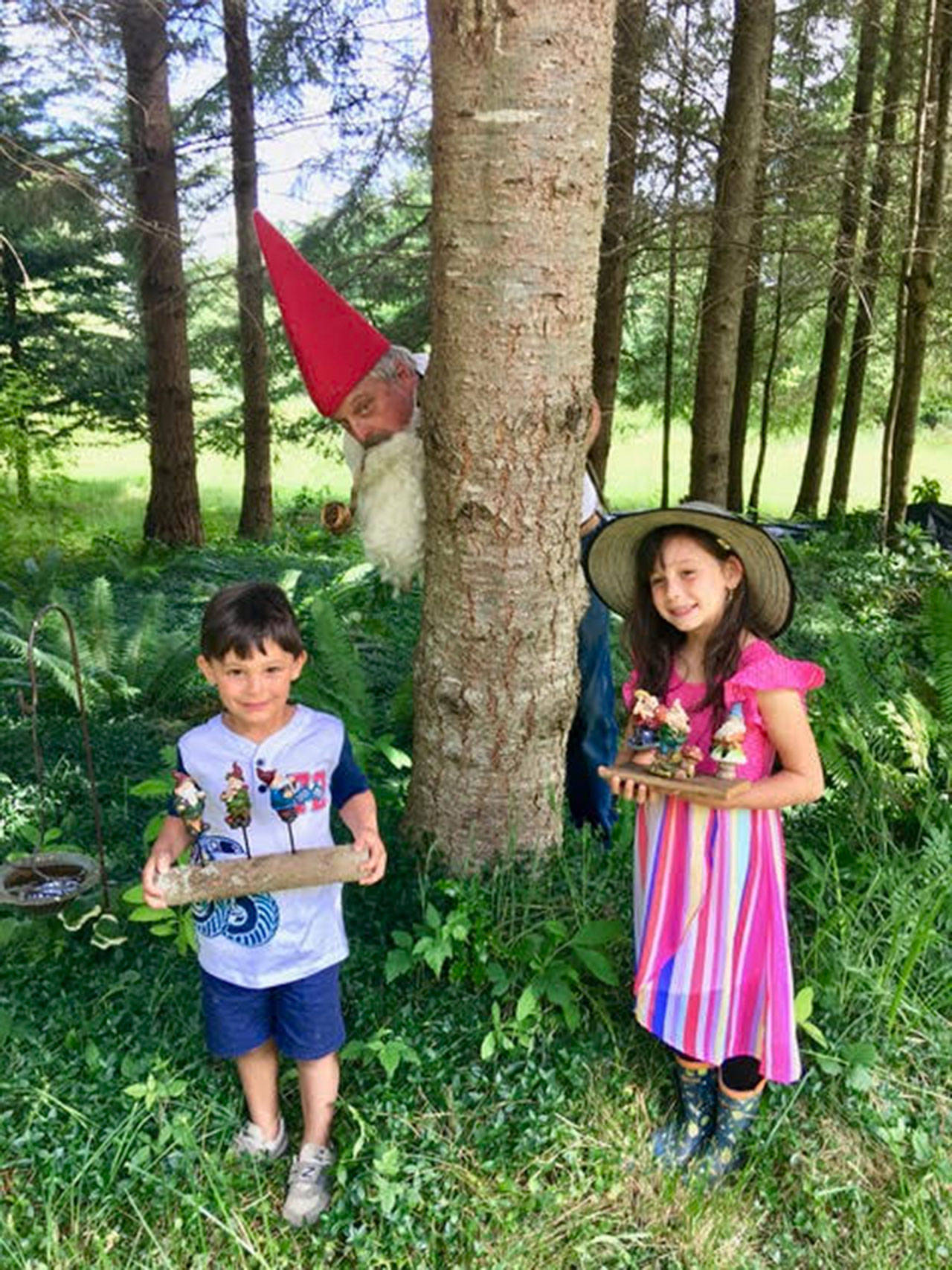 Whimsical Woods’ Grandpa Gnome (Val Jackson), pictured here with his grandchildren, will tell his gnome tales at the June 22 Sequim Farmers Market. Submitted photo