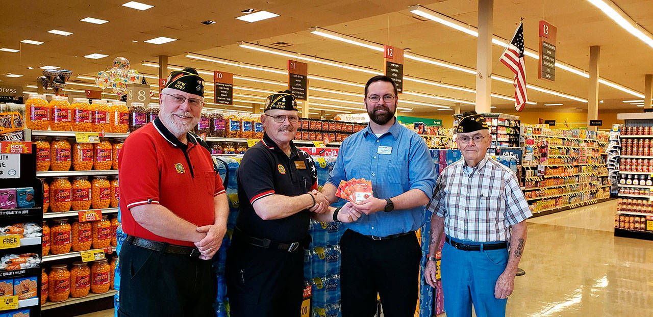 Sequim Safeway Store Director Joe Barton presents gift cards to Carlsborg VFW Post 6787 Commander Rod Lee and members of the Post Tom Fenner and Don Hyatt. Submitted photo