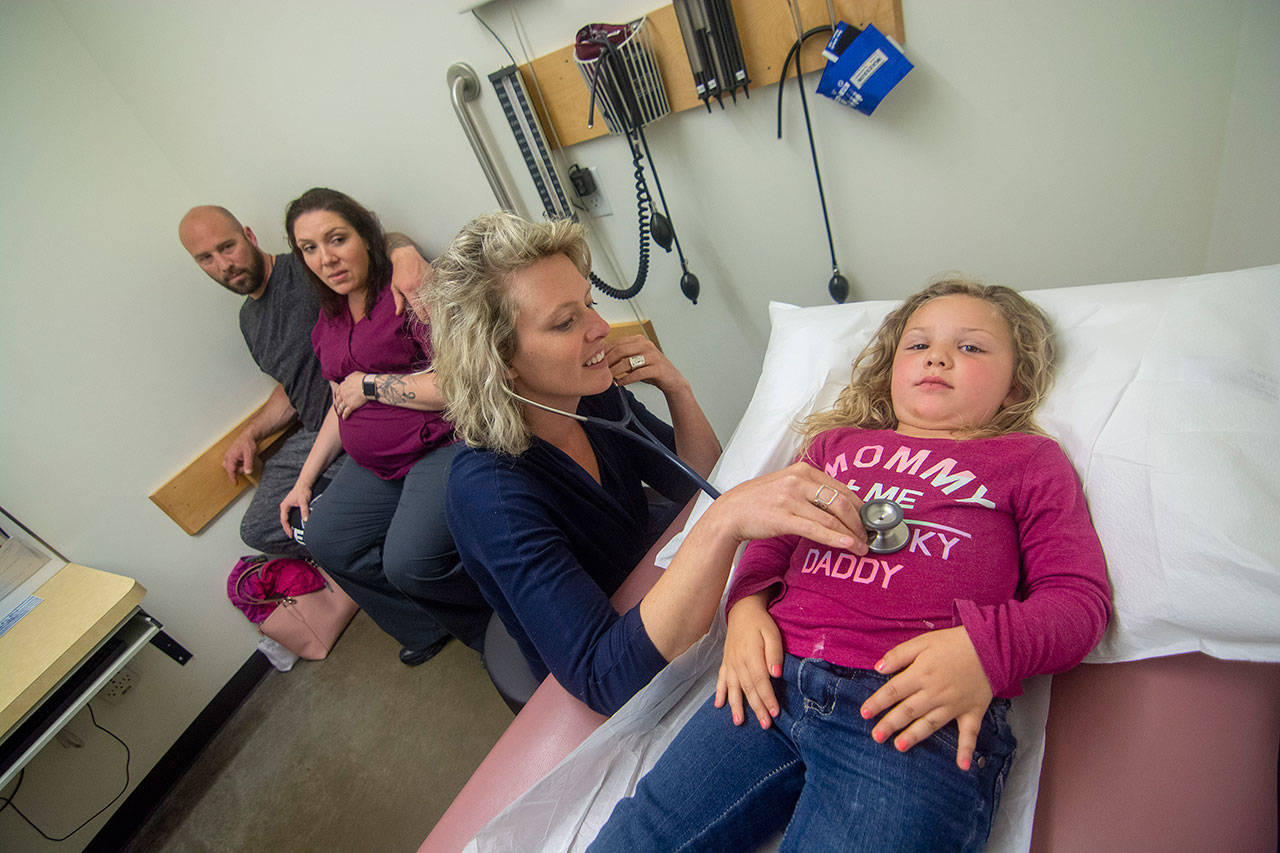 Dr. Jessica Colwell examines Azila Black, 3, as her parents Ryan and Amber Black look on at North Olympic Healthcare Network. Photo by Jesse Major/Peninsula Daily News