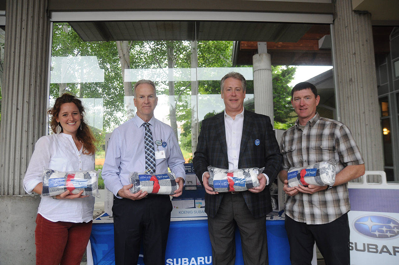 Helping distribute blankets as part of the “Subaru Loves to Care” program at Olympic Medical Cancer Center in Sequim last week are, from left: Mikel Townsley, patient navigator; director Dean Putt; Bill Koenig of Koenig Subaru, and Rob Edwards. Sequim Gazette photo by Michael Dashiell