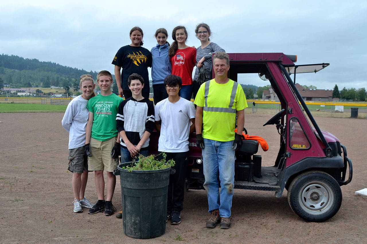 On July 10, Sequim-Shiso City Student Exchange students, chaperones and staff with the City of Sequim cleaned up a softball field as part of the Shiso City Student Exchange “Park-A-Thon” fundraiser. Students will also paint dog park obstacles on July 17. Participants included, from front left, Jennifer Imholt, parent chaperone, Jackson Imholt, 14, Ayden Humphries, 14, Calem Klinger, 14, Gary Butler, Sequim parks maintenance worker; top from left, Angel Wagner, 13, Kari Olson, 14, Anastasia Updike, 14, and Karlie Viada, 14. Not pictured students Julia Jack, Danika Chen and Ruby Coulson, and chaperones Jon Jack and Vicki Kingsolver. Sequim Gazette photo by Matthew Nash