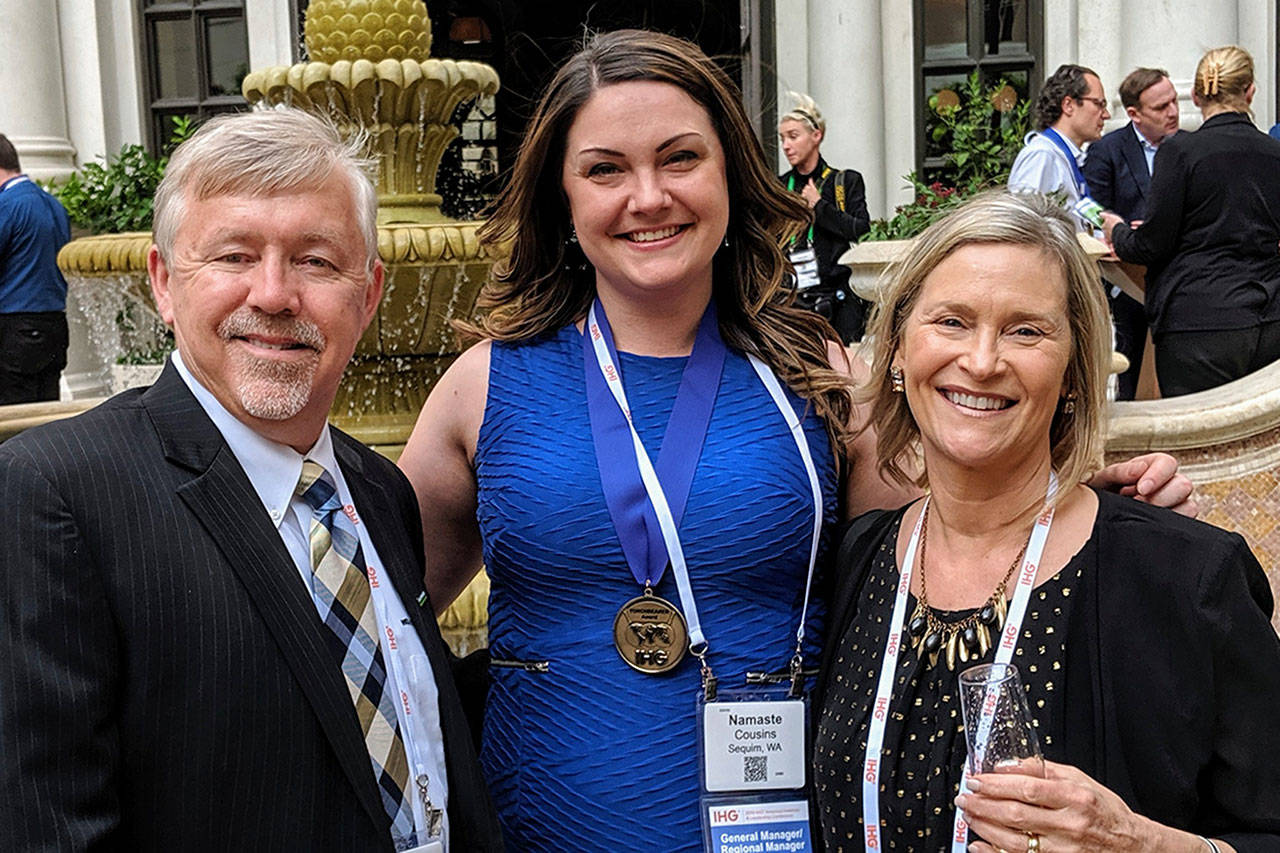 Bret and Trisha Wirta, owners of The Holiday Inn Express in Sequim, stand with its general manger Namaste Cousins, center, after the hotel won its franchise’s Torchbearer Award putting it in the top five percent of the franchise. Submitted photo
